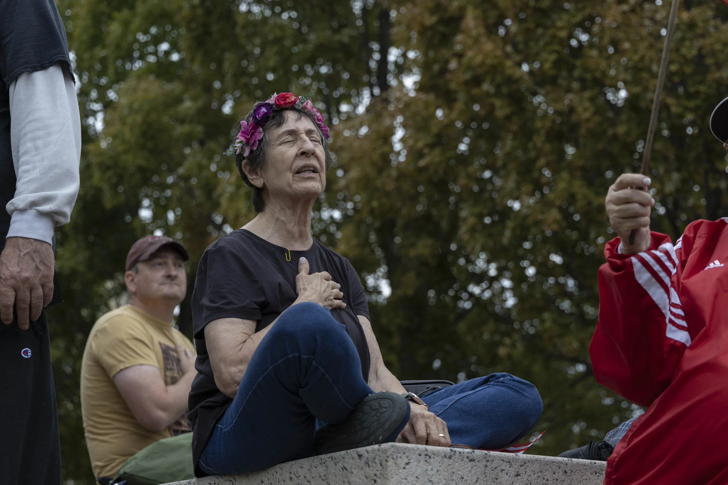 A woman, who did not provide the Daily Egyptian with a name, holds her hand over her heart for the National Anthem at the No Kings protest Oct. 18, 2025 in front of the Abraham Lincoln statue at the Illinois State Capitol in Springfield, Illinois.