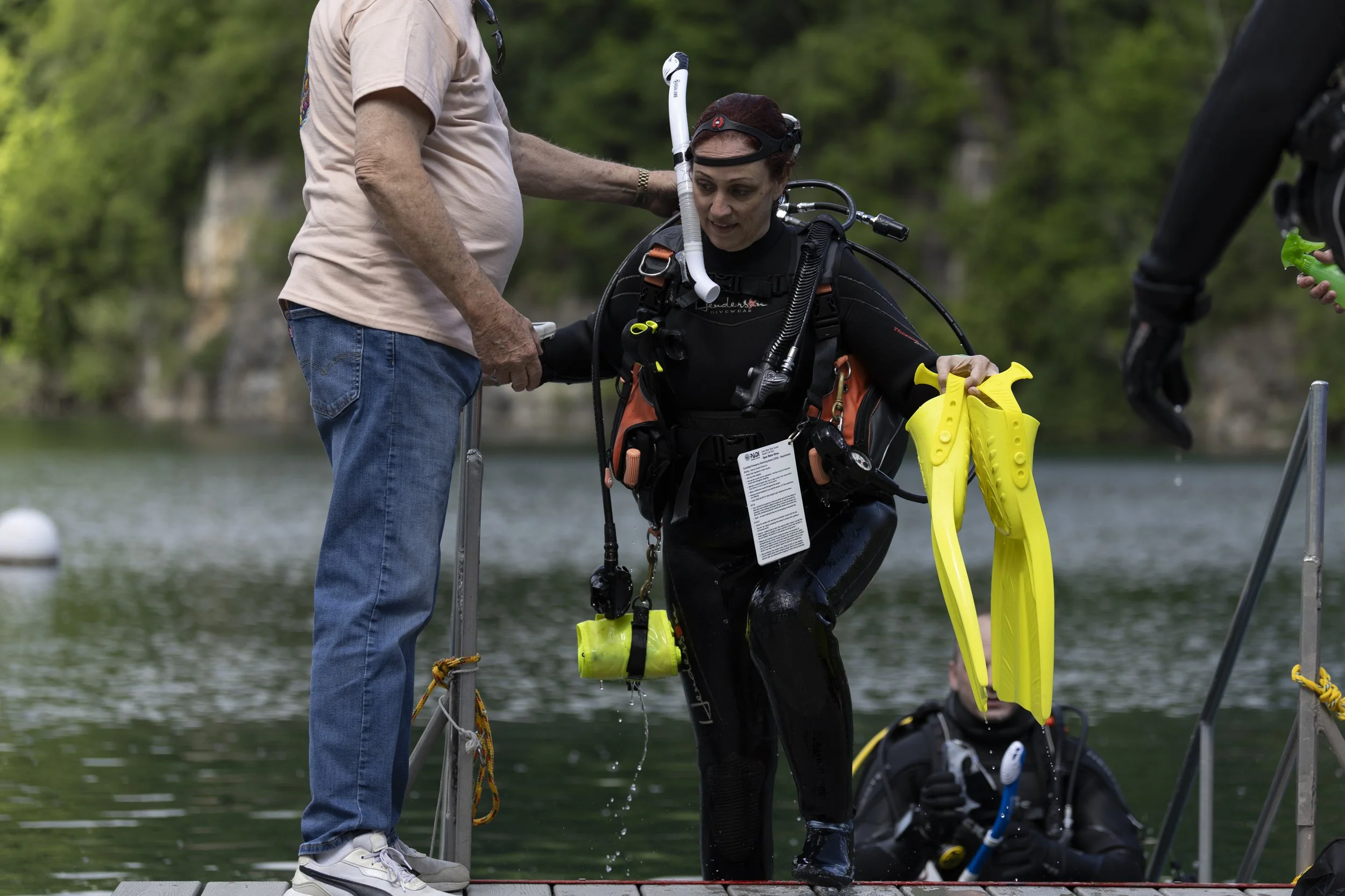 A Great American Diver employee helps owner Heather Kiswani up the stairs after a dive event April 25, 2026 at Mermet Springs in Belknap, Illinois.