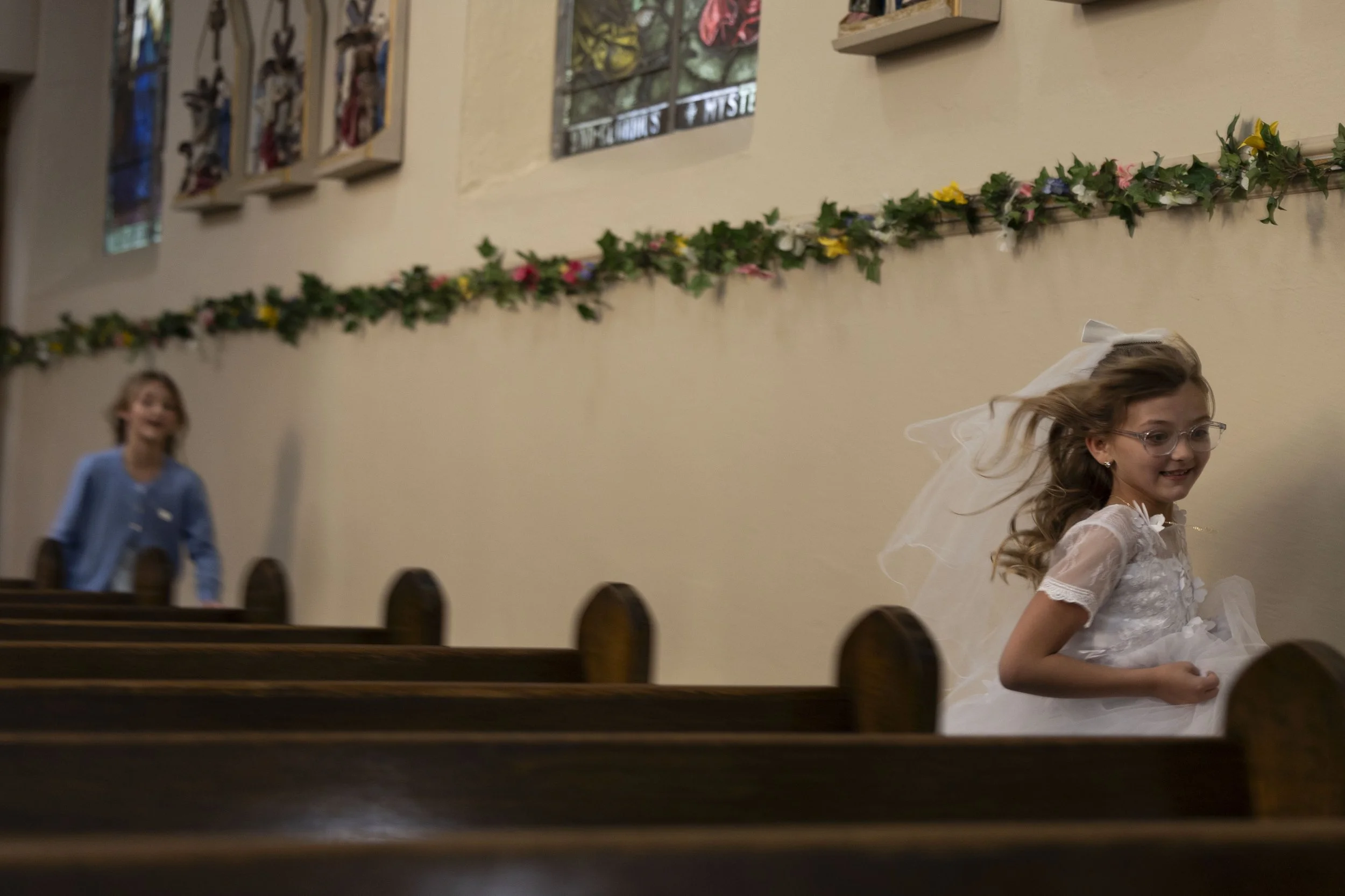 Marcella Haney runs away from her sister Lydia Haney after her first Communion April 11, 2026 at St. Andrew’s Catholic Church in Murphysboro, Illinois. 