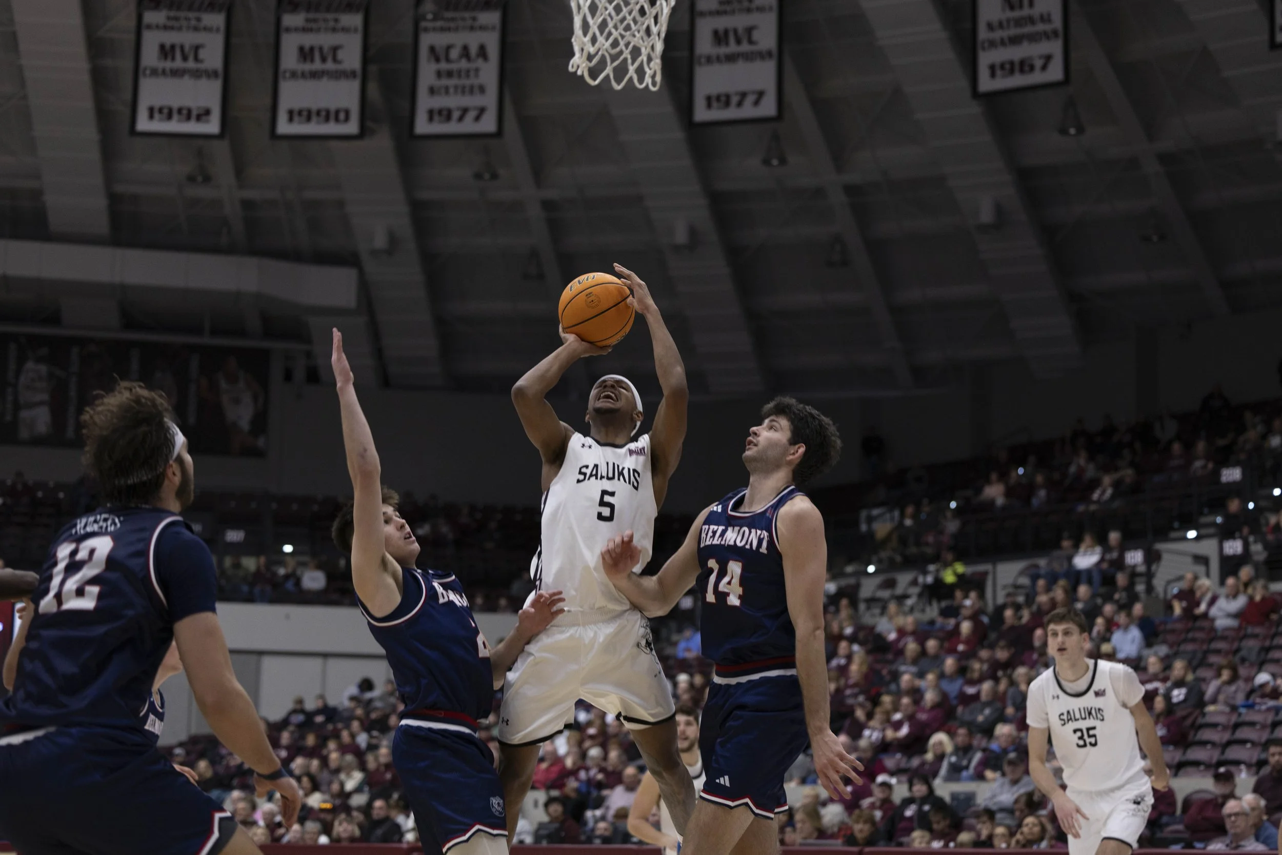 Jalen Haynes (5) jumps to attempt to score while Jack Smiley (2) and Sam Orme (14) sandwich him to stop him Jan. 17, 2026 at the Banterra Center in Carbondale, Illinois.