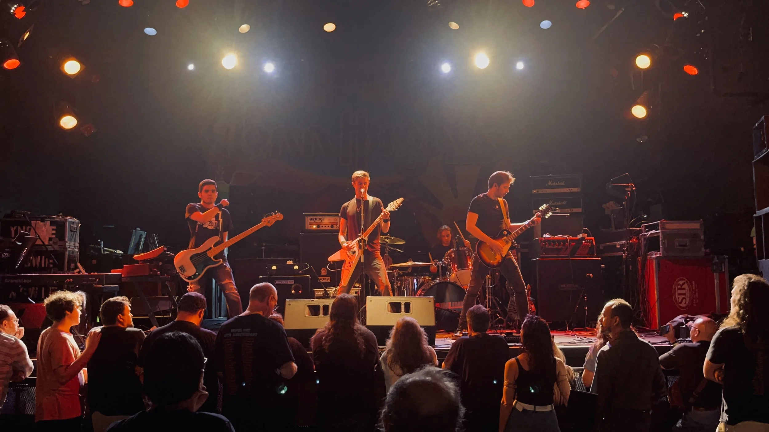 Mainline performing live at The Chance Theater with crowd in front.