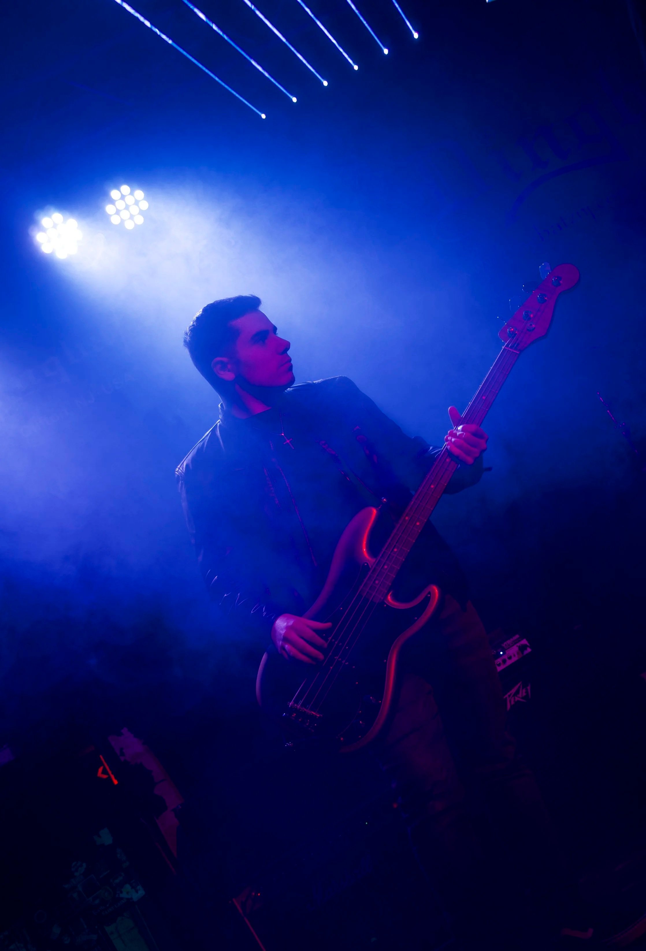 Bassist Anthony Schettino performing at Dingbatz with lights, lasers, and smoke overhead.