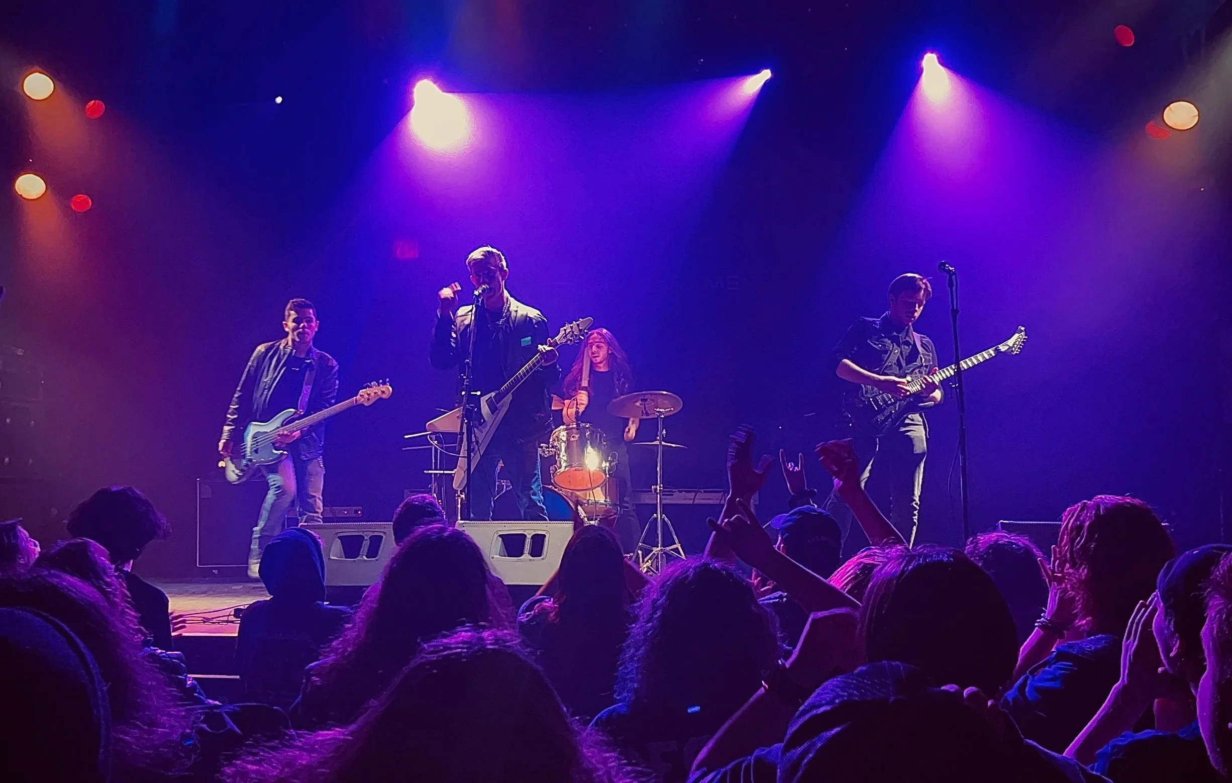 Mainline performing live at The Chance Theater with crowd in front and purple stage lights.