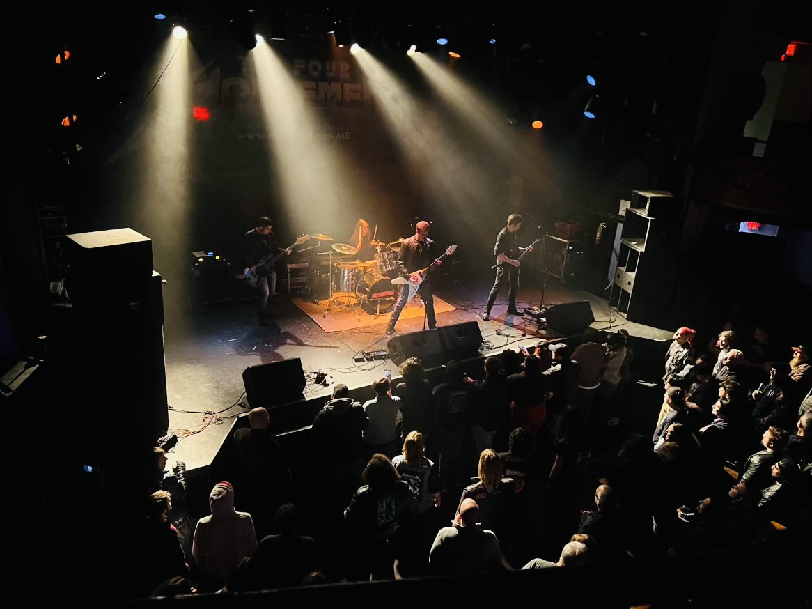 Mainline performing live on stage under bright lights with an audience watching at The Chance Theater