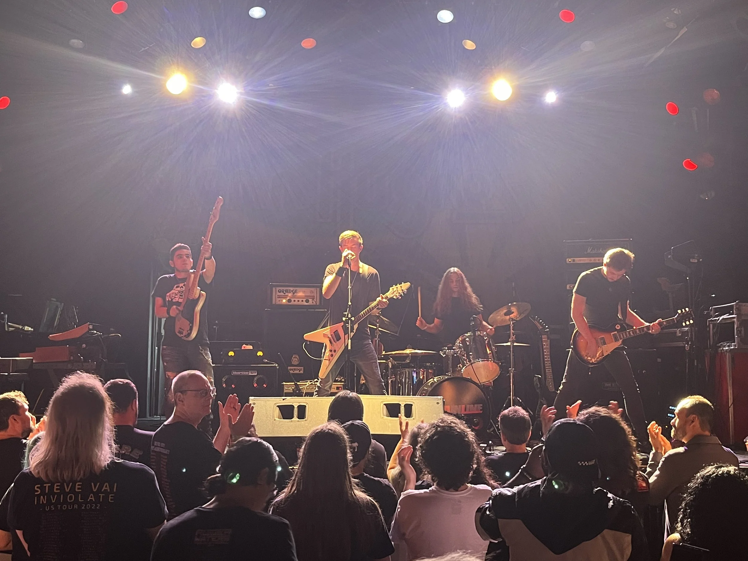 Mainline performing live at The Chance Theater with crowd in front.