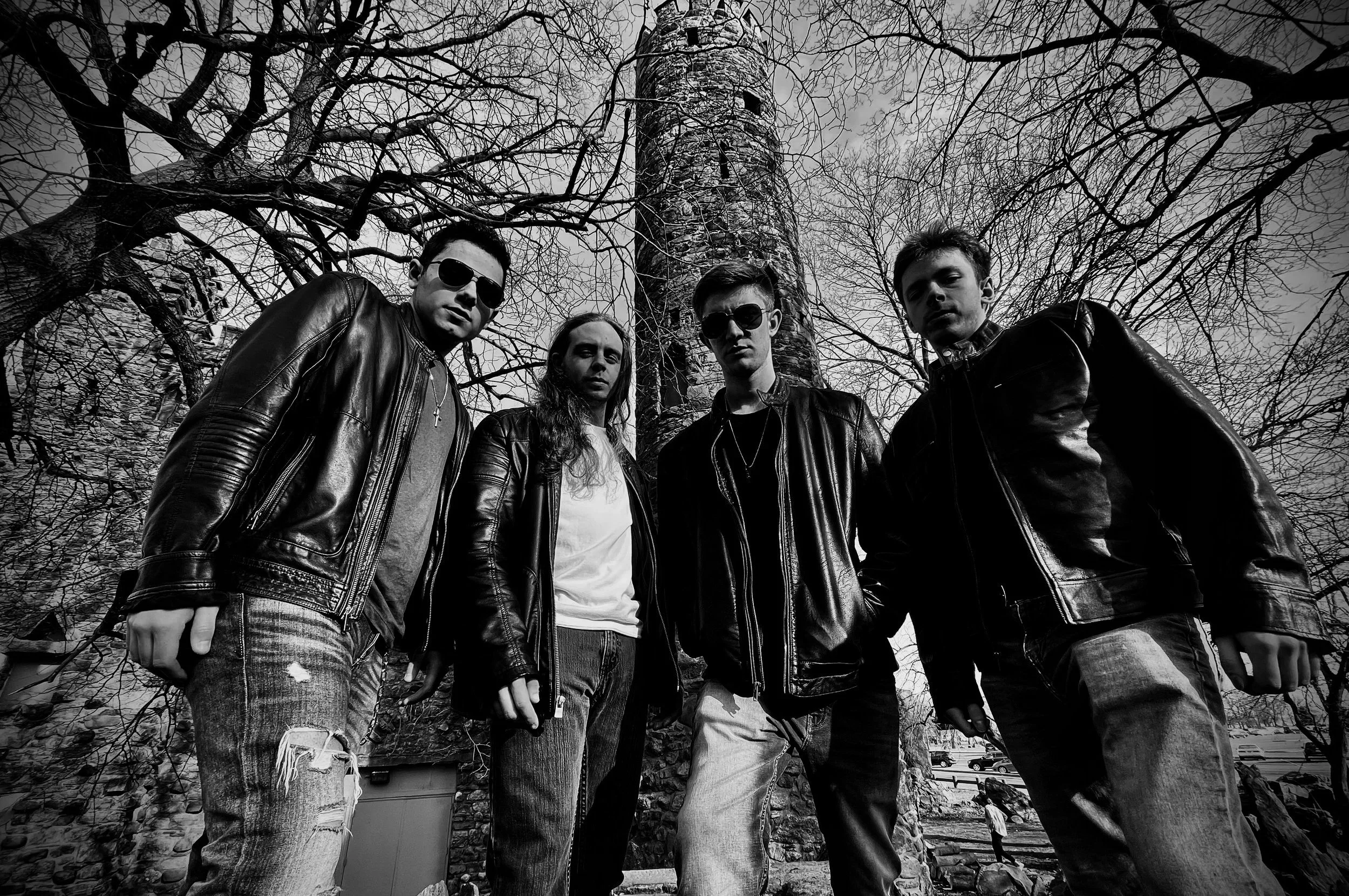 Black and white promotional shot of Mainline outside castle with tower in background