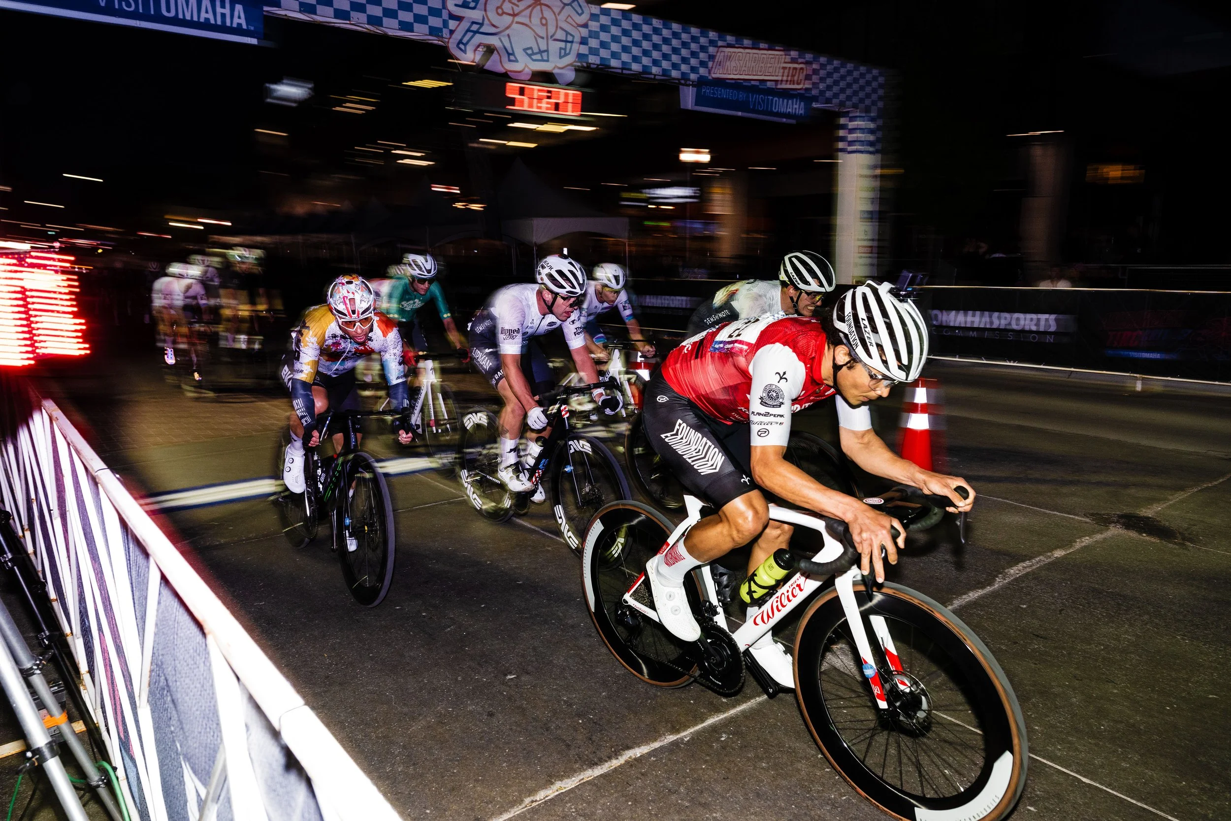 Close-up of a group of racers, wearing helmets and gear to race in the Aksarben Tirc Criterium.