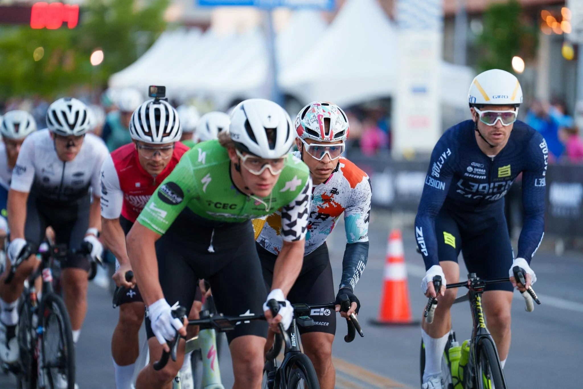 Close-up of a group of racers, wearing helmets and gear to race in the Aksarben Tirc Criterium.