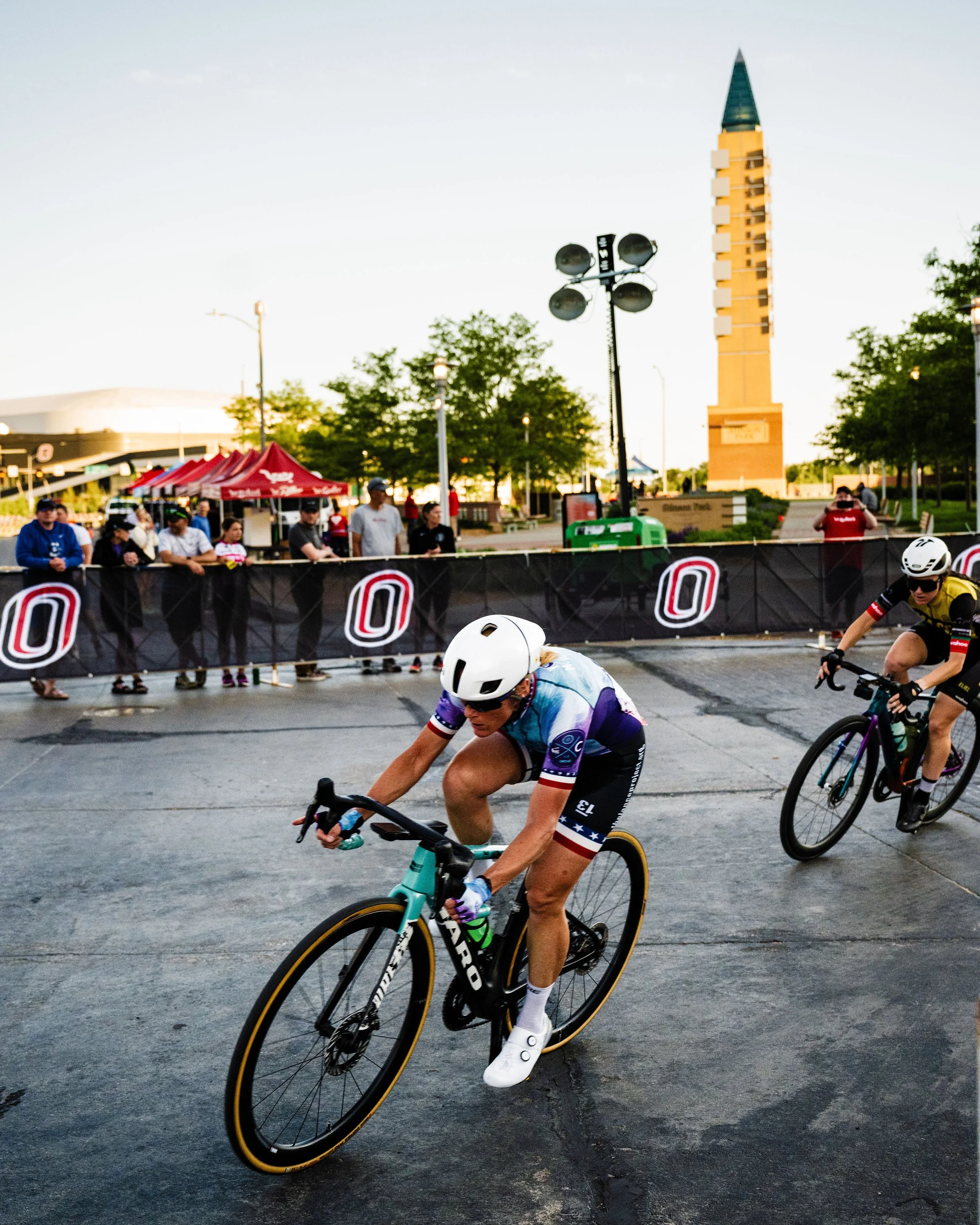 Close-up of a group of racers, wearing helmets and gear to race in the Aksarben Tirc Criterium.