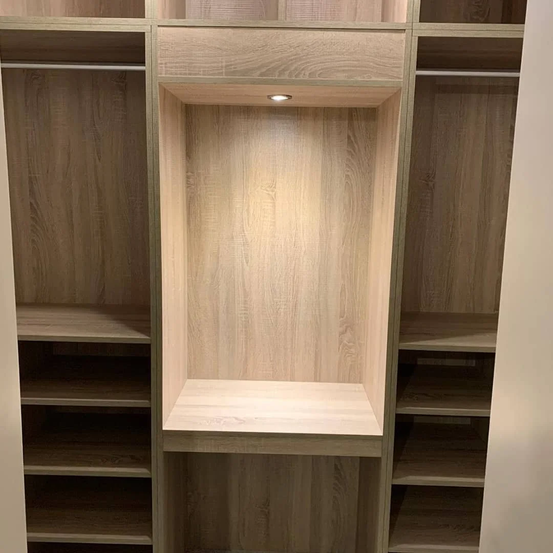 Empty wooden closet with a built-in spotlight in the center.