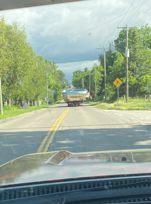 A car is driving on a rural road and appears to be floating or flying in the air.