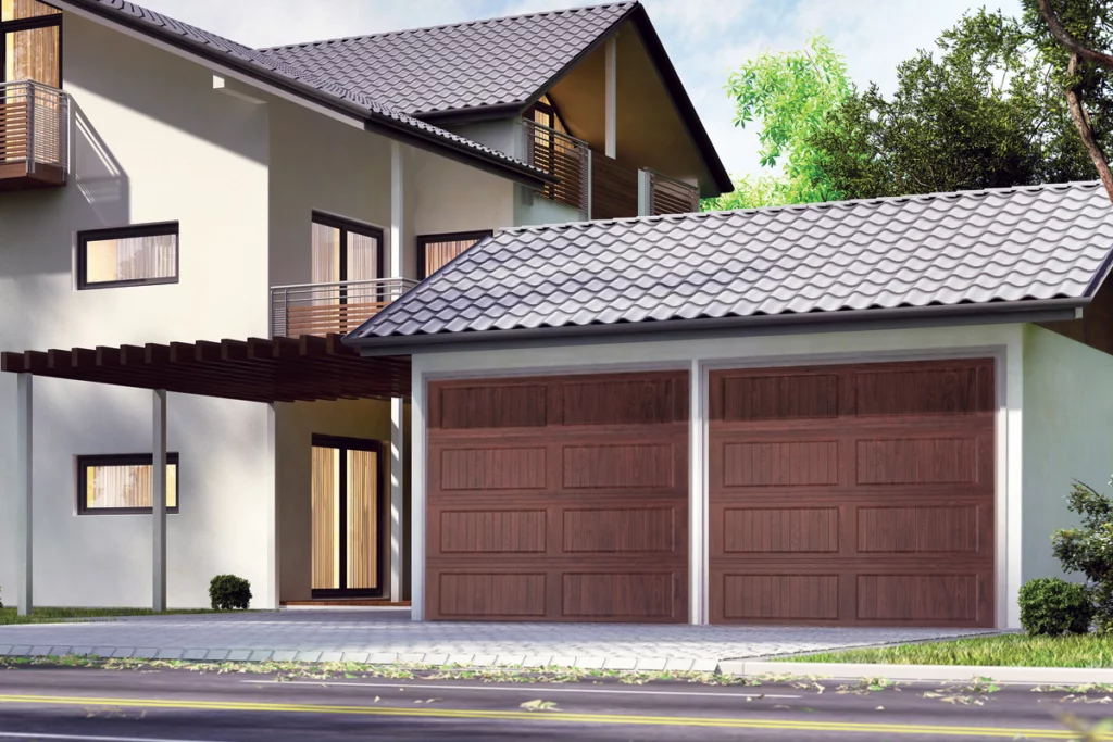 Modern two-story house with white exterior walls, dark gray roof, balconies with metal railings, and a two-car garage with wooden doors. There is a driveway, small plants, and trees around the house.
