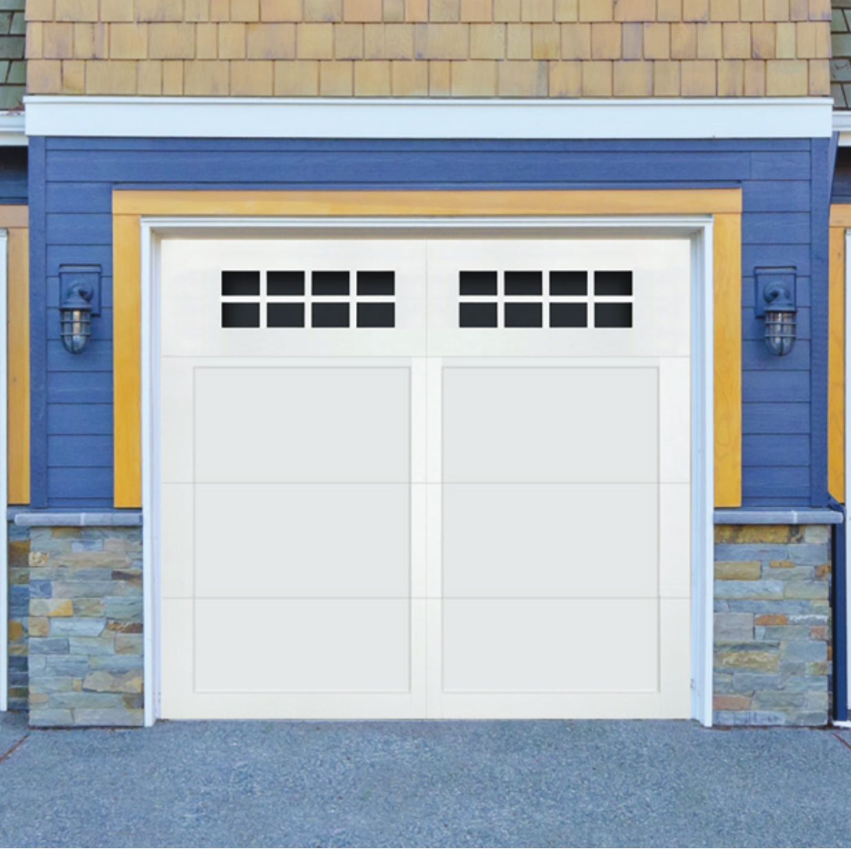 White garage door with small square windows near the top, surrounded by blue and yellow trim, stone accents at the base, and two exterior lights on either side.
