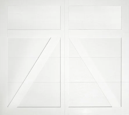 Close-up of a white garage door with diagonal and horizontal panel lines.