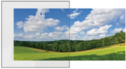 Scenic landscape with green fields, trees in distance, and a partly cloudy sky.