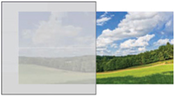 Comparison of a dull, overcast sky with a bright, sunny sky over a green landscape.