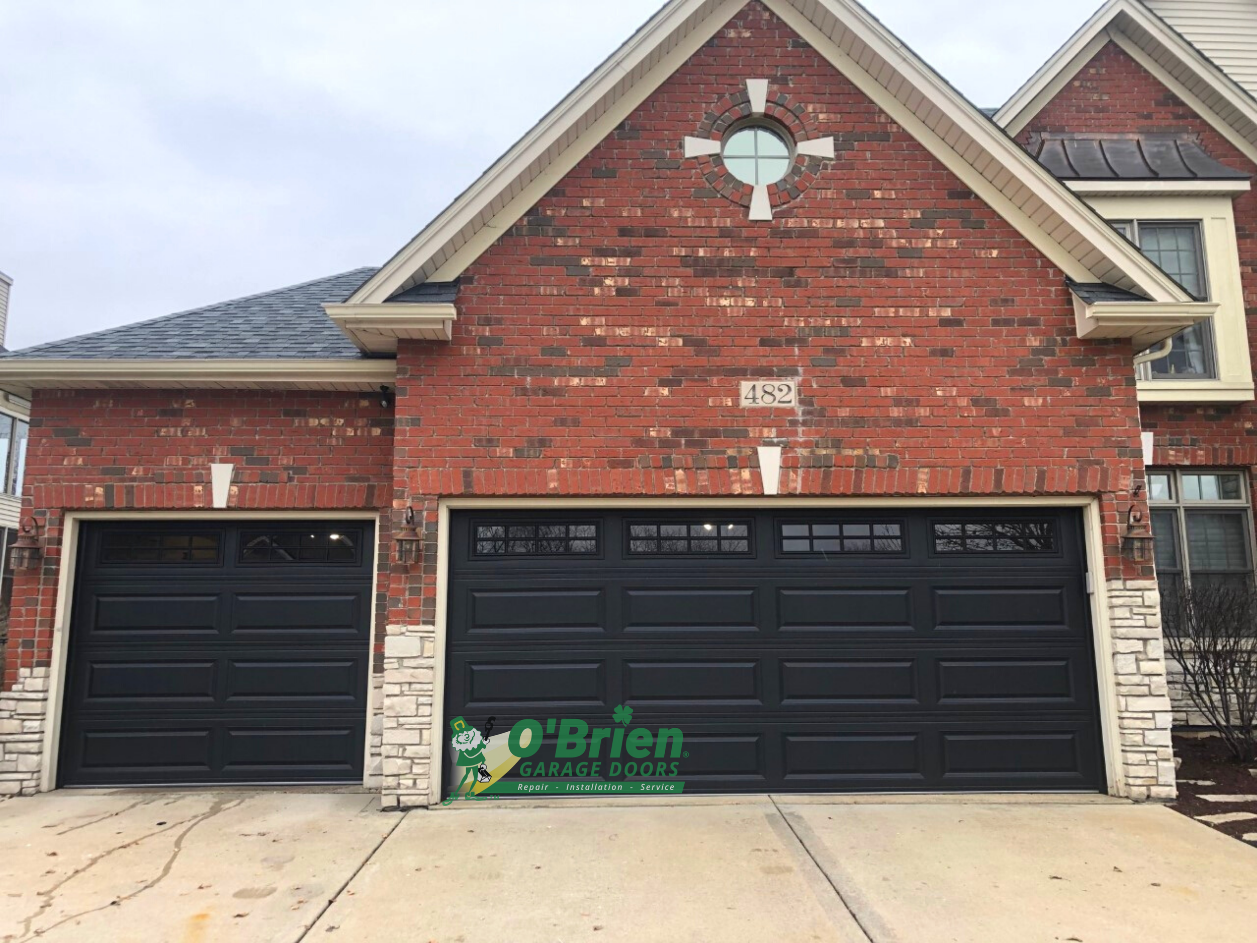 Brick House With 2 Black Garage Doors
