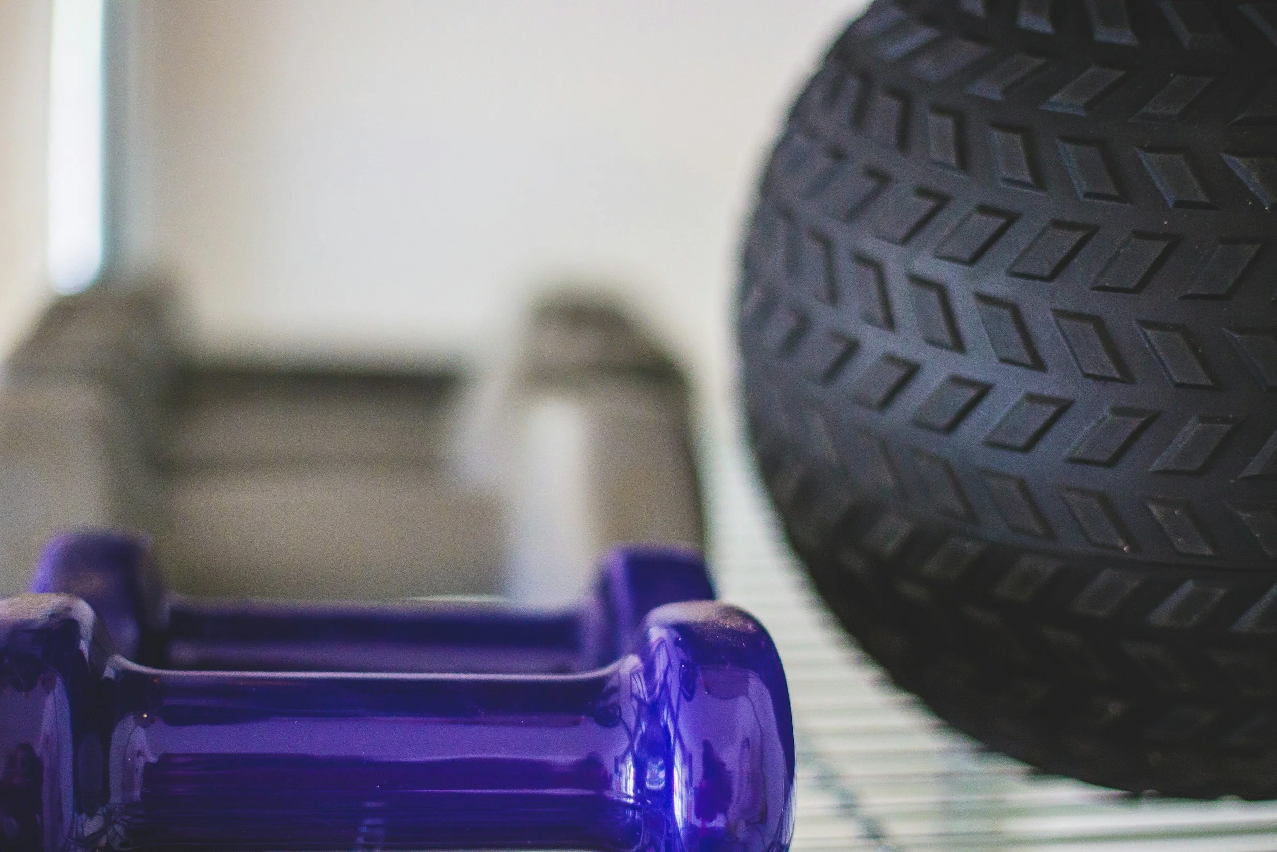 Close-up of a row of purple ink pads on a white and black striped surface with a tire in the background.