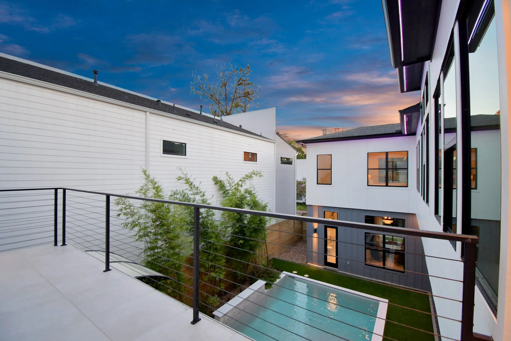 An exclusive private courtyard with a resort-style pool, framed by modern architecture and lush landscaping.