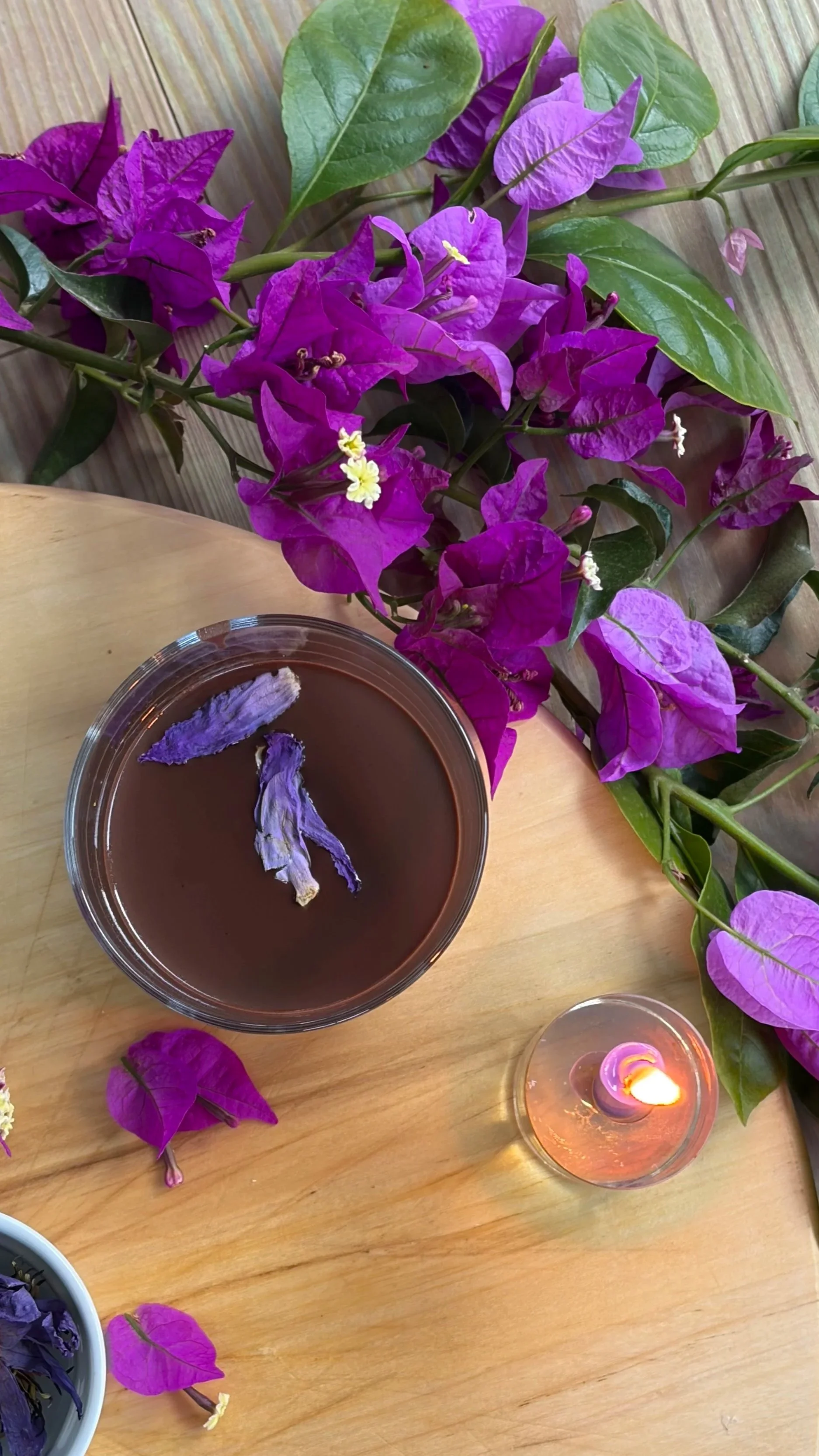 a cup of cacao surrounded by purple flowers