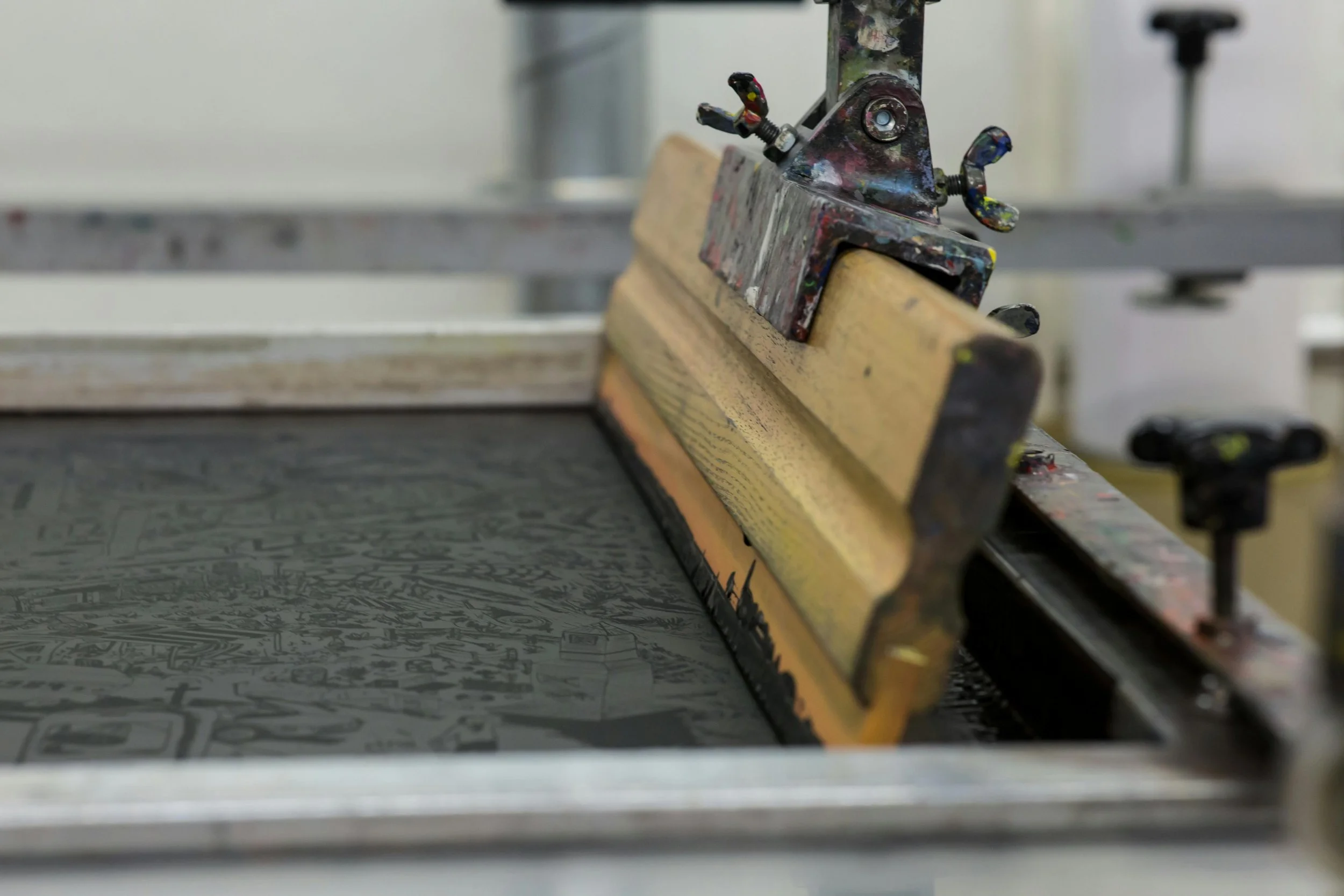 A printmaking brayer roller on an intaglio printing plate in a print studio.