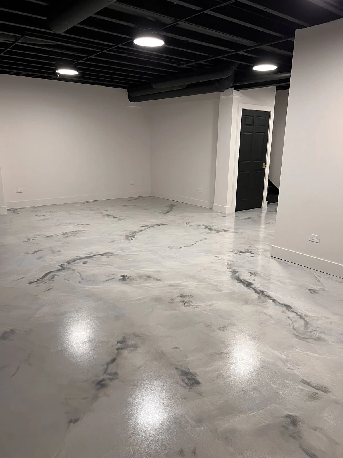 empty basement room with black ceiling, recessed lighting, and a custom metallic epoxy floor that looks like marble