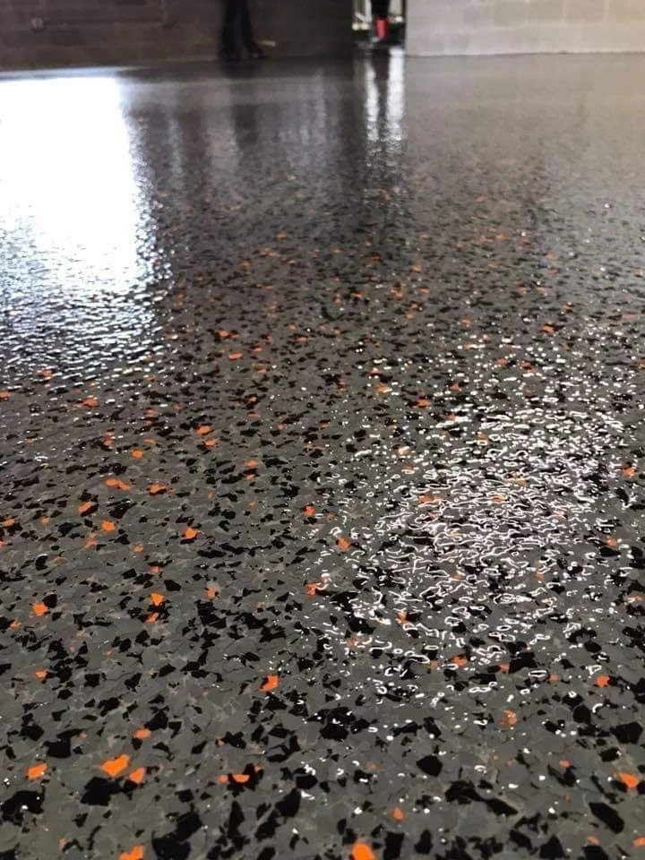 black and grey chip flake epoxy floor with orange flakes inside of garage 