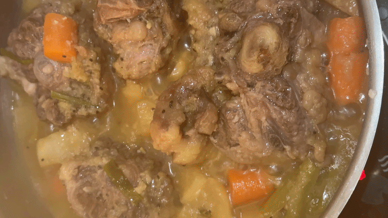 From above hands of unrecognizable woman rubbing aromatic spices into piece of raw meat over parchment paper