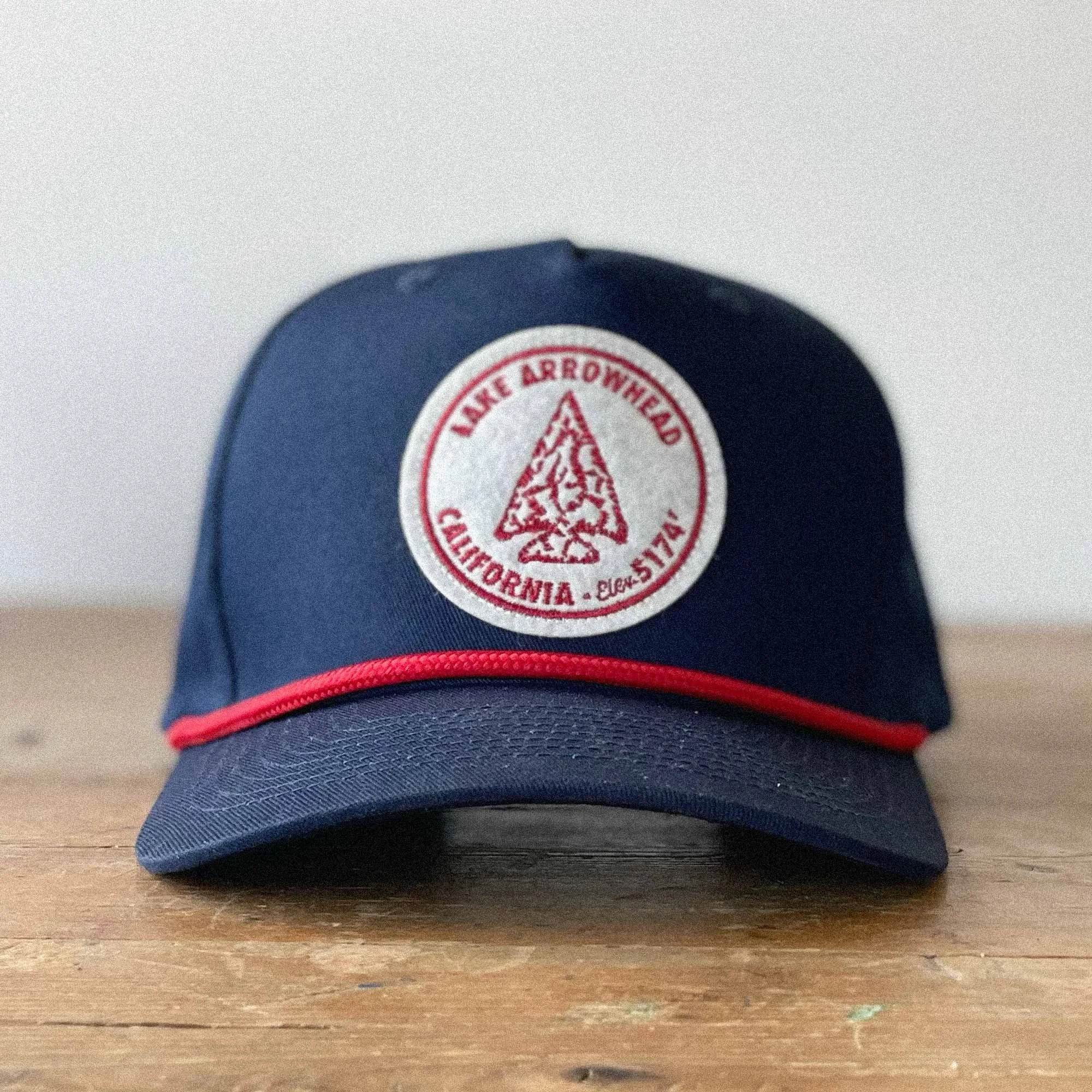 A Navy 5-panel snapback hat featuring a lake arrowhead patch.