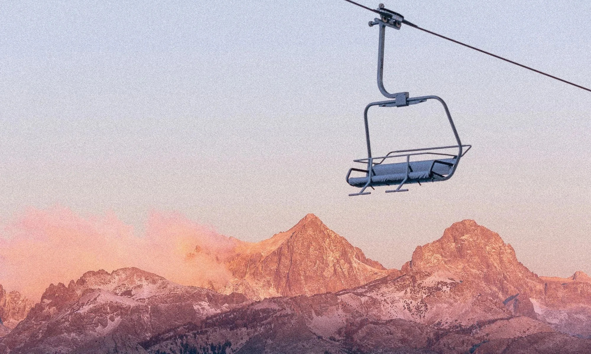 Empty chairlift above Mammoth Mountain and the Eastern Sierra at sunset