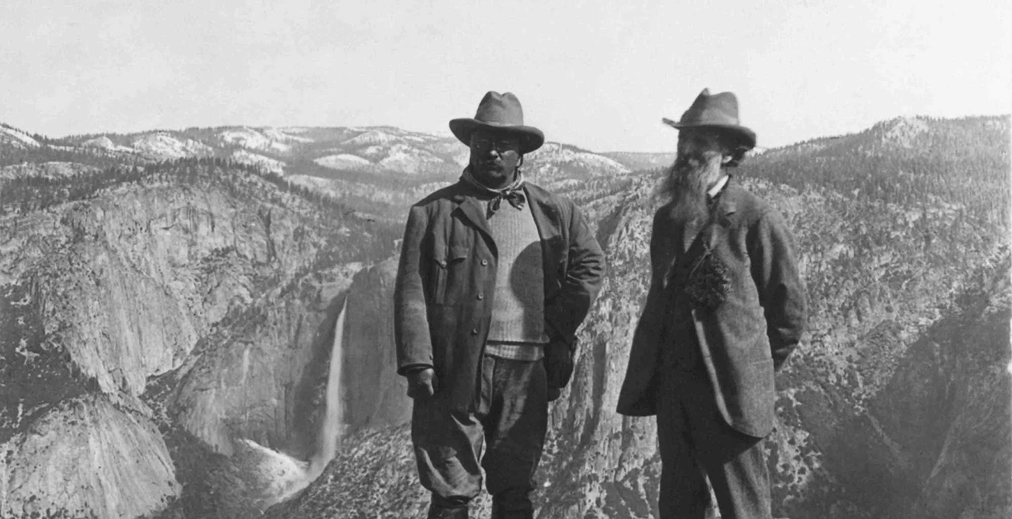 A historical photo of John Muir looking out over Yosemite National Park