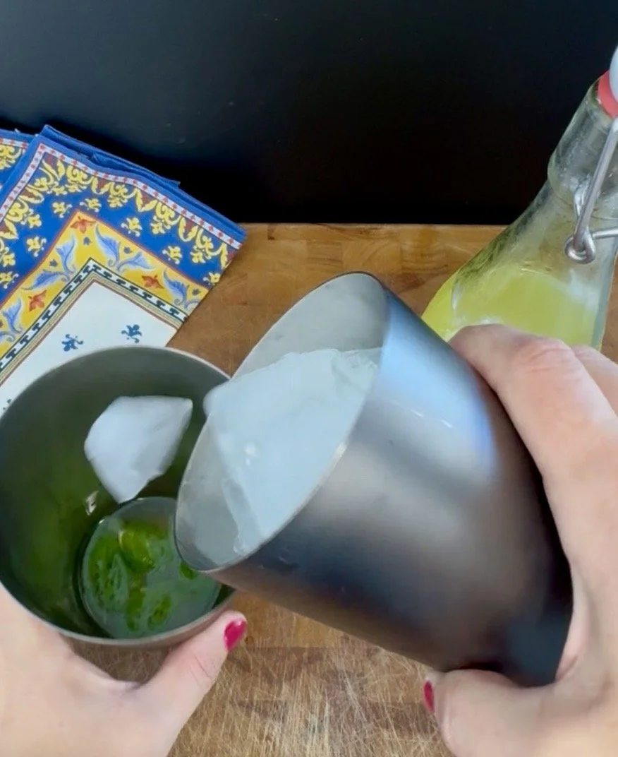 Pouring an Almalfi Basil Smash cocktail into a rocks glass.