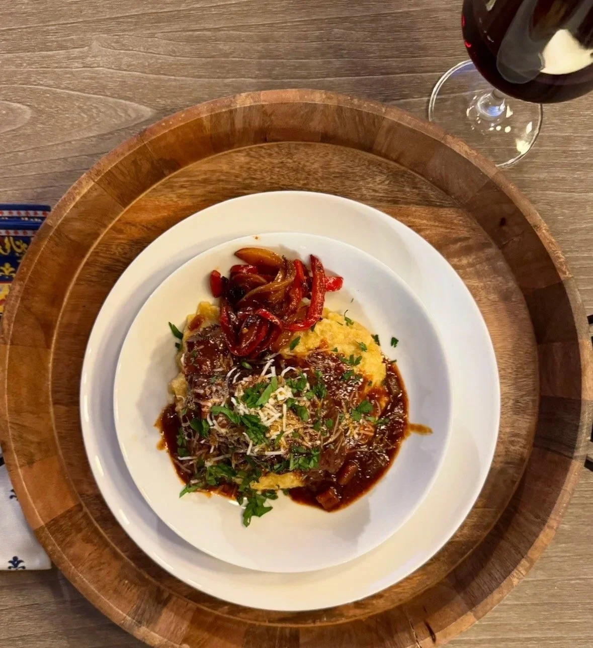 Braised short ribs served over creamy polenta with peperonata, Parmigiano Reggiano, and parsley.