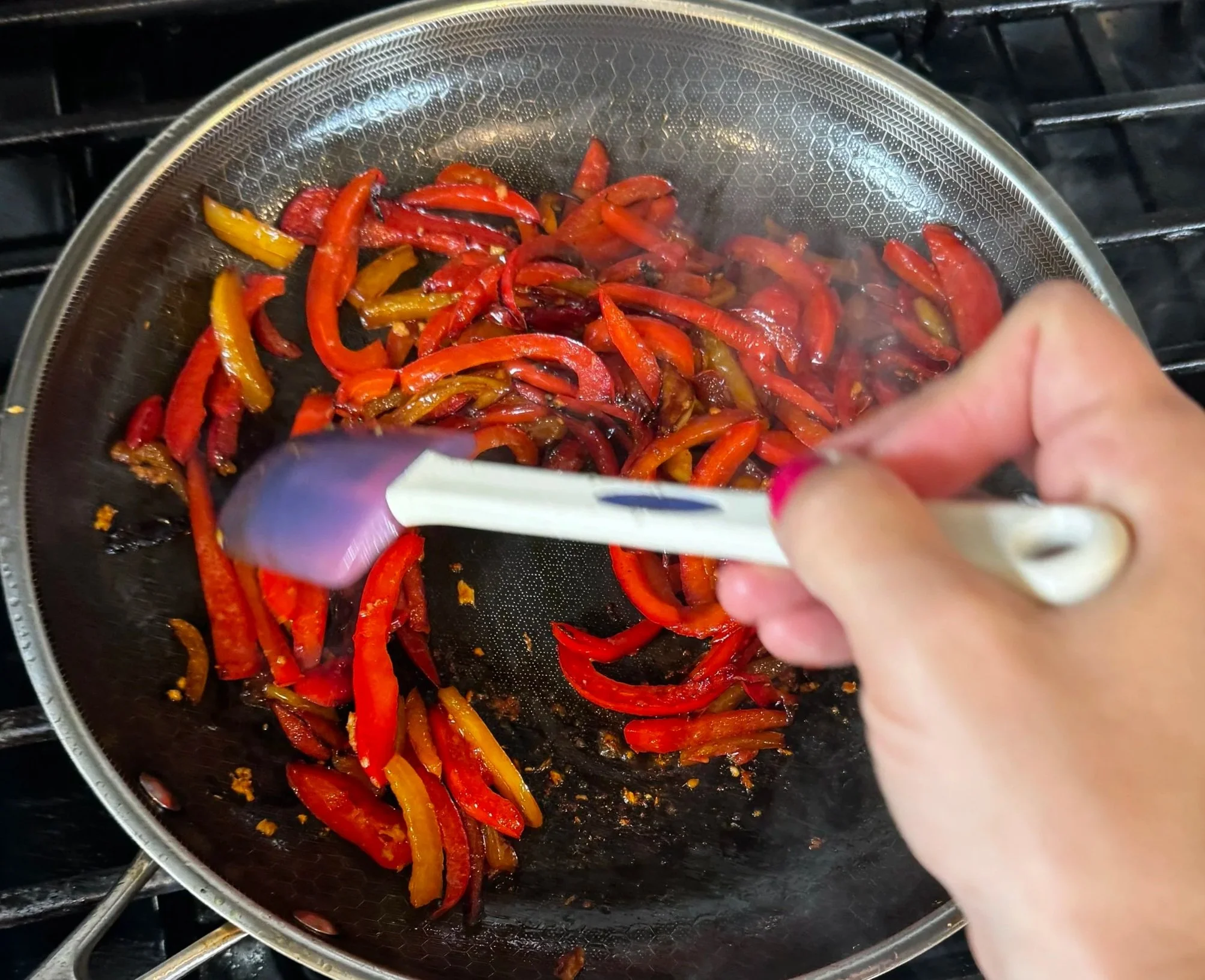 Finished peperonata cooking in skillet until soft and glossy