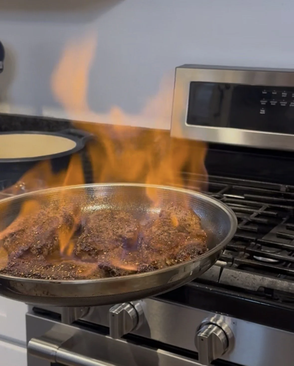 Cognac flambé for Whiskey Ridge Steak au Poivre - flames rising from the pan on the stovetop.