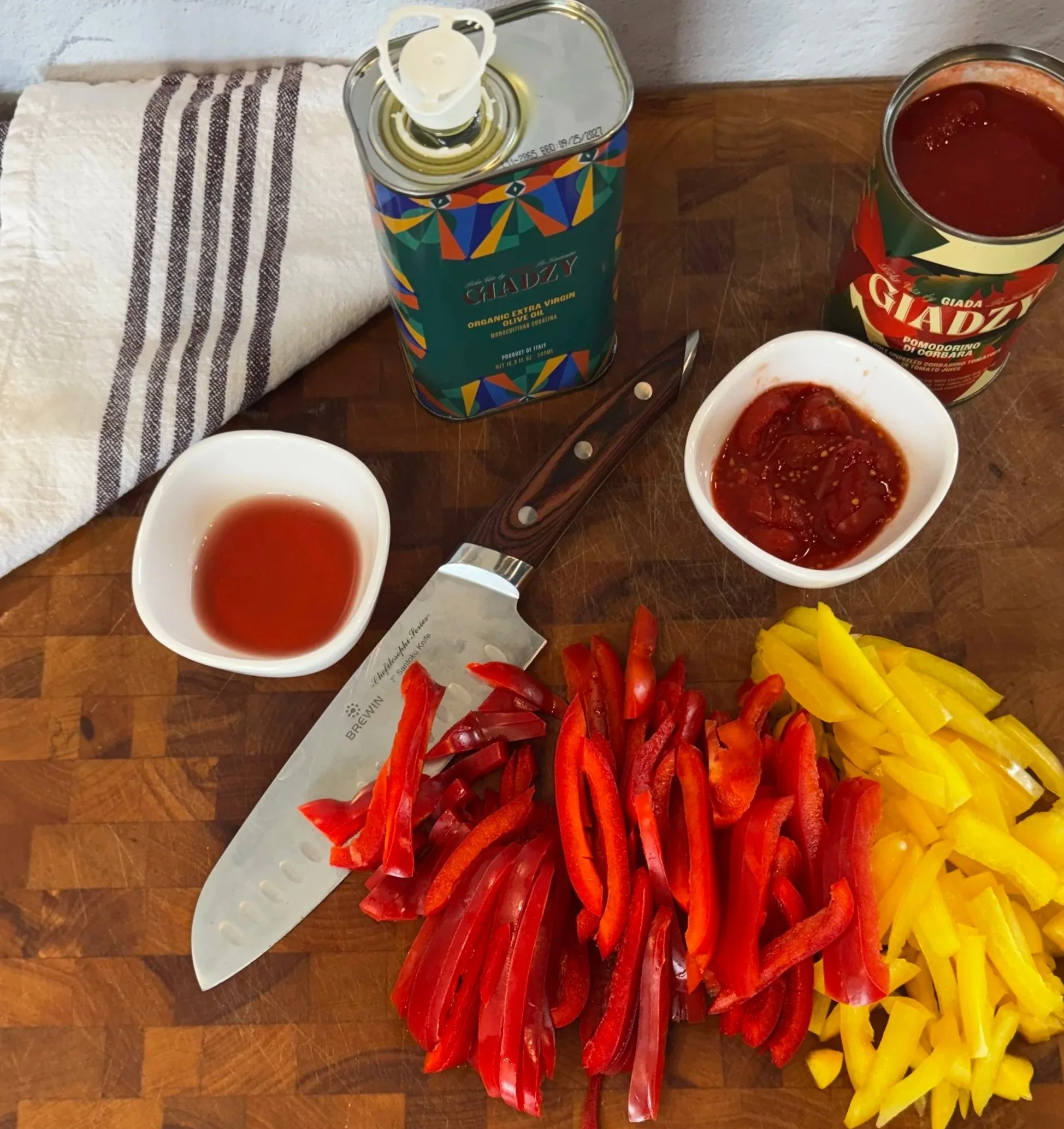 Ingredients for Italian peperonata including bell peppers, olive oil, tomatoes, and red wine vinegar