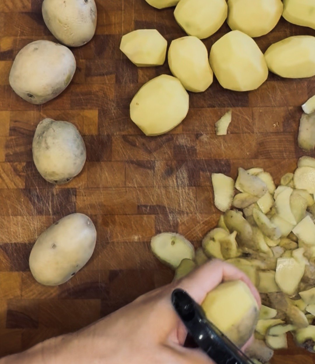 Hand peeling and slicing raw potatoes for Pommes Anna