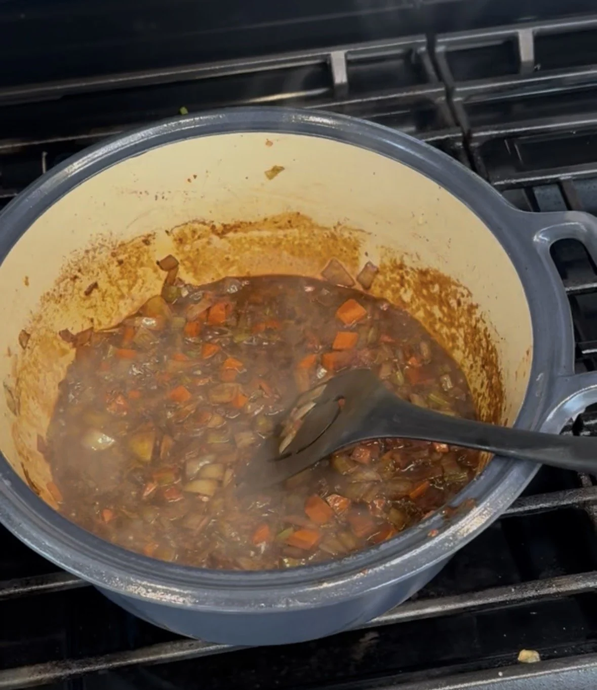 Red wine braising sauce simmering and reducing in a Dutch oven.