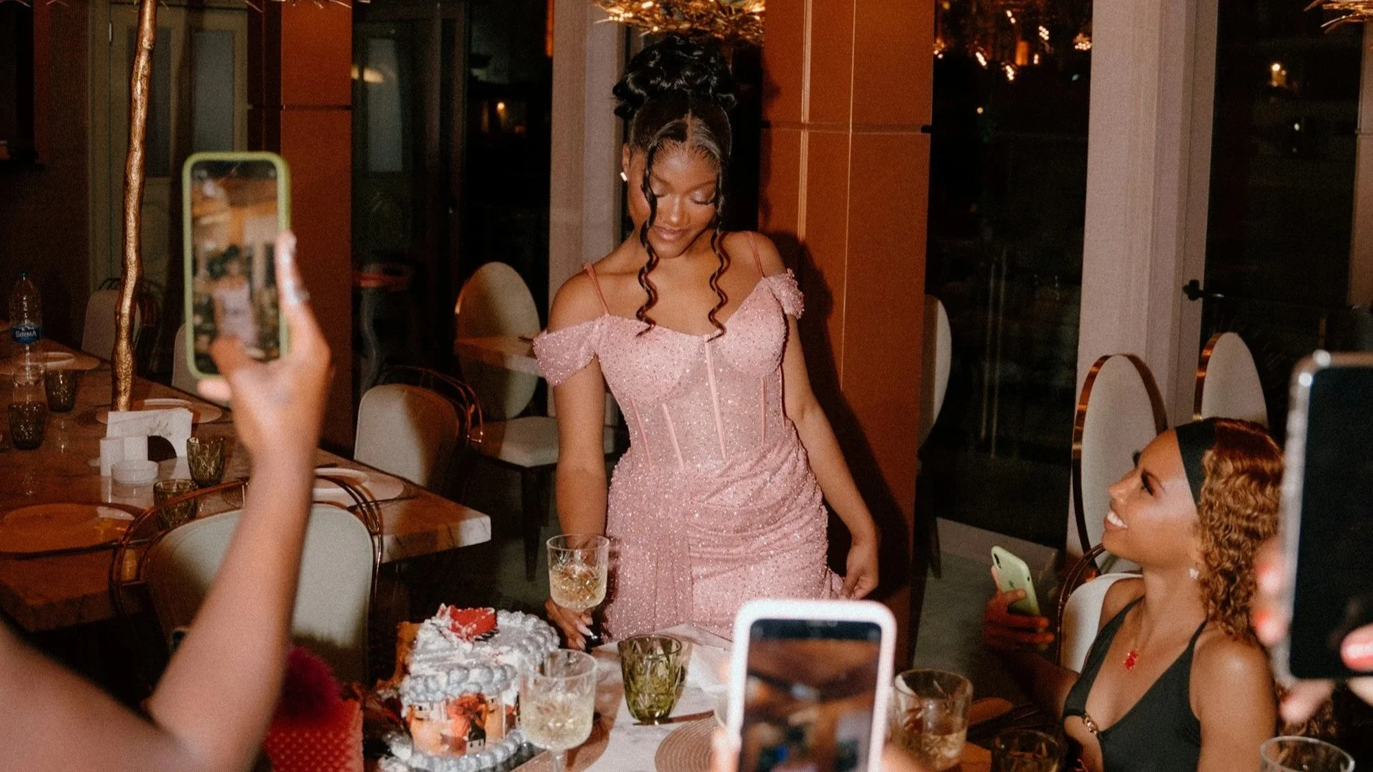 woman in a pink dress holding a glass of champagne