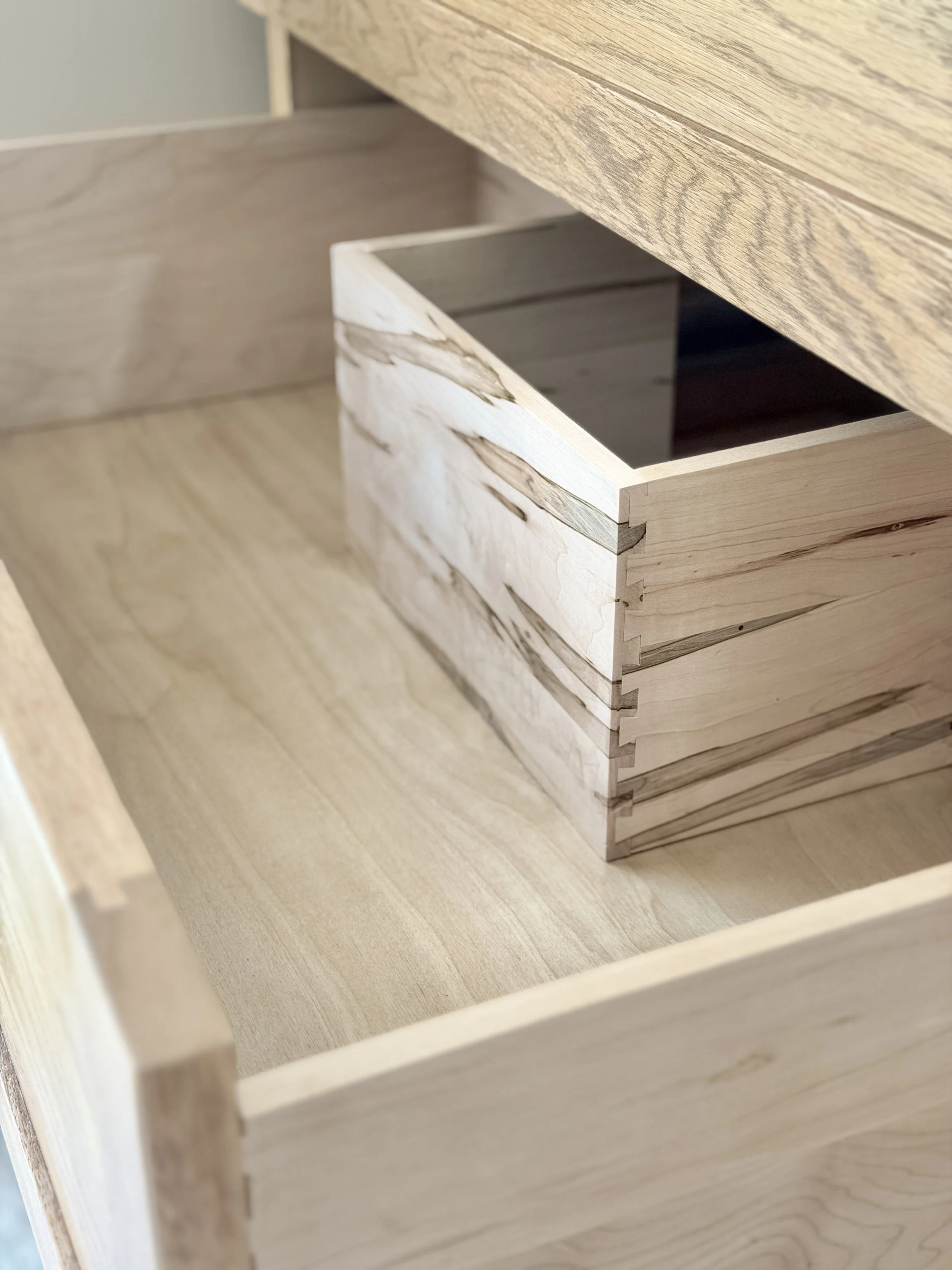 Detail of vanity drawer showing our dovetail joints and cut out going around sink plumbing.