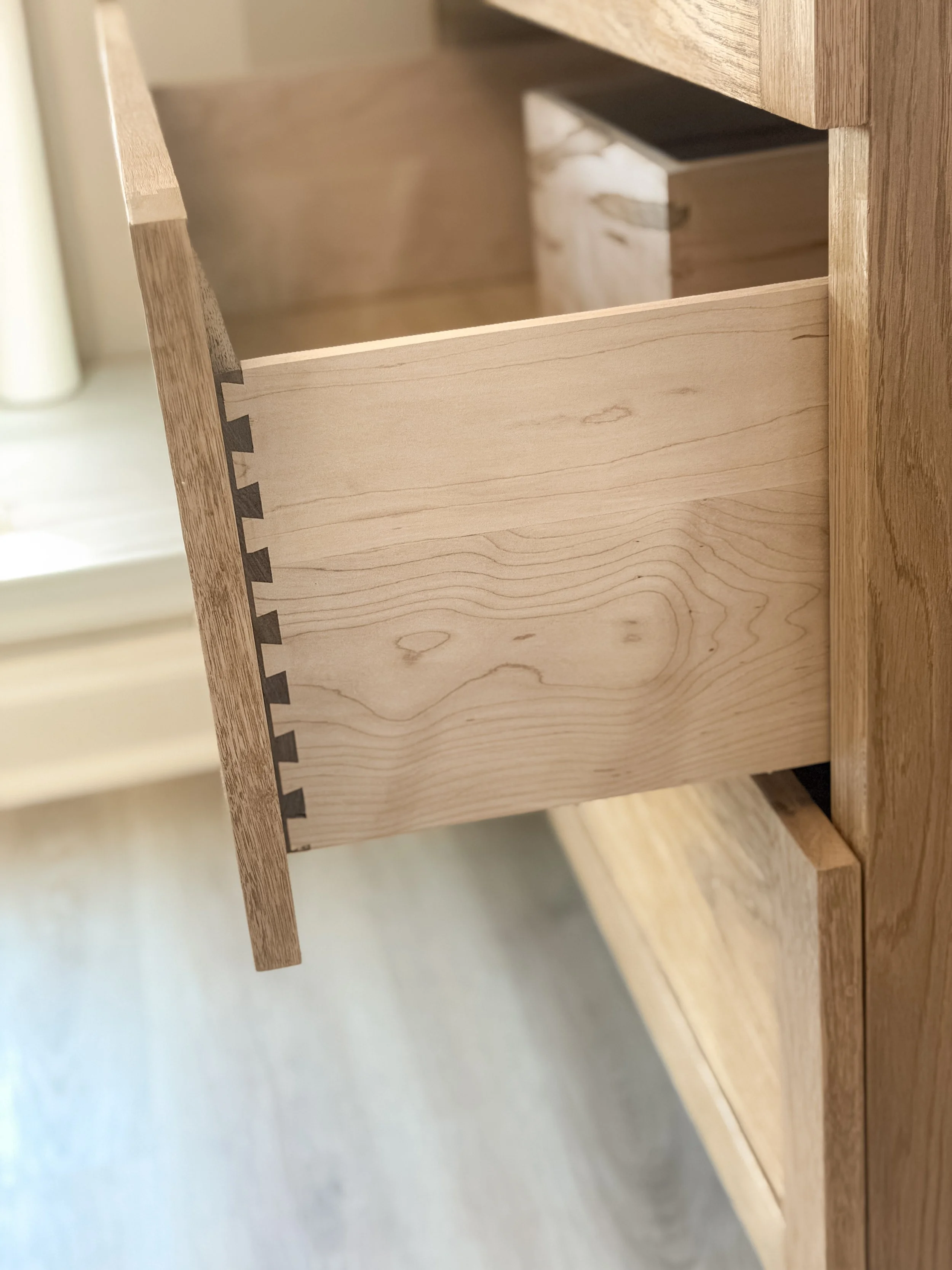 Close-up of our hand made dovetail drawer in our Monroe inspired vanity, partially open, showing part of the interior.