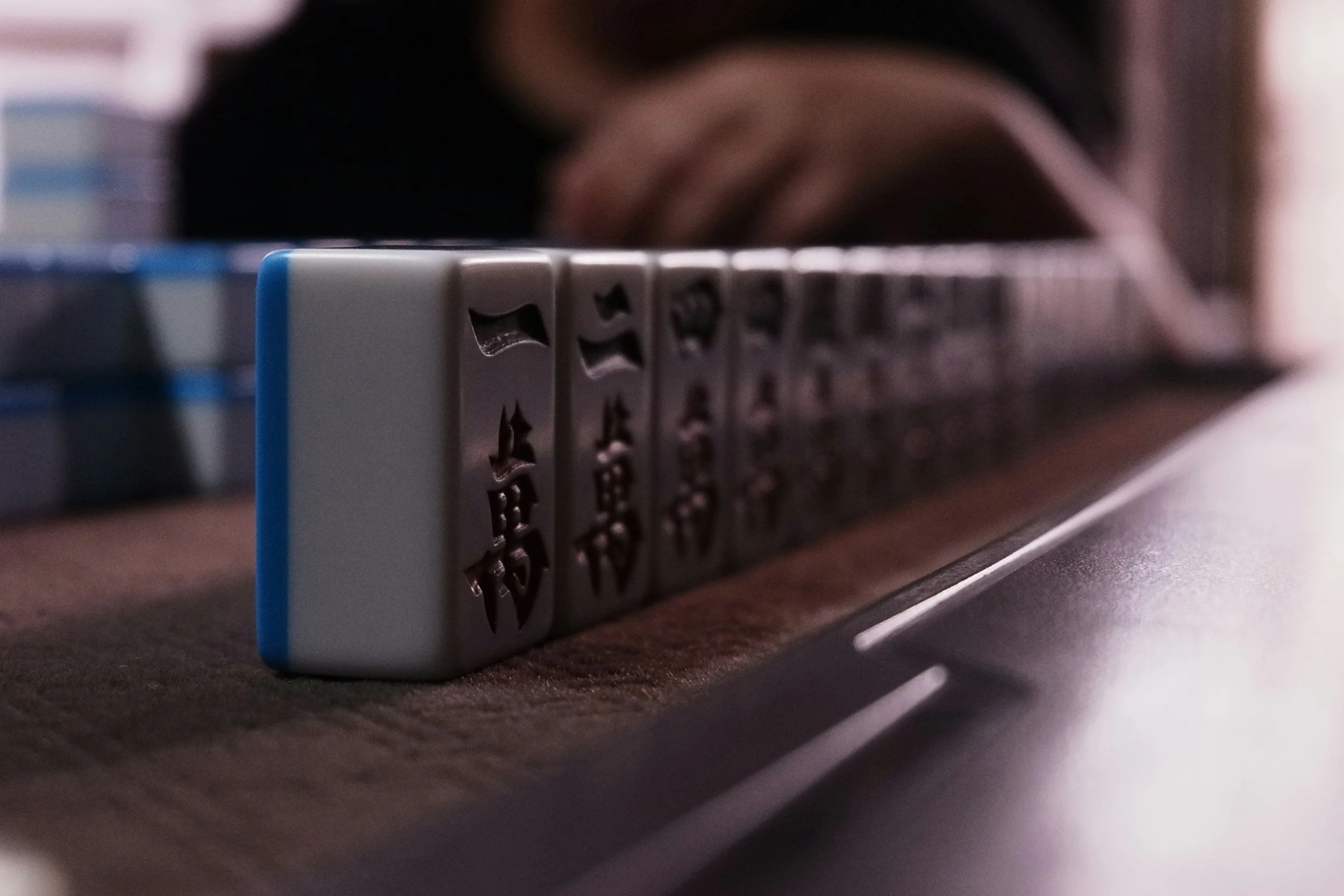 Close-up of a domino tile with star shapes, resting on a dark surface, with blurred background.