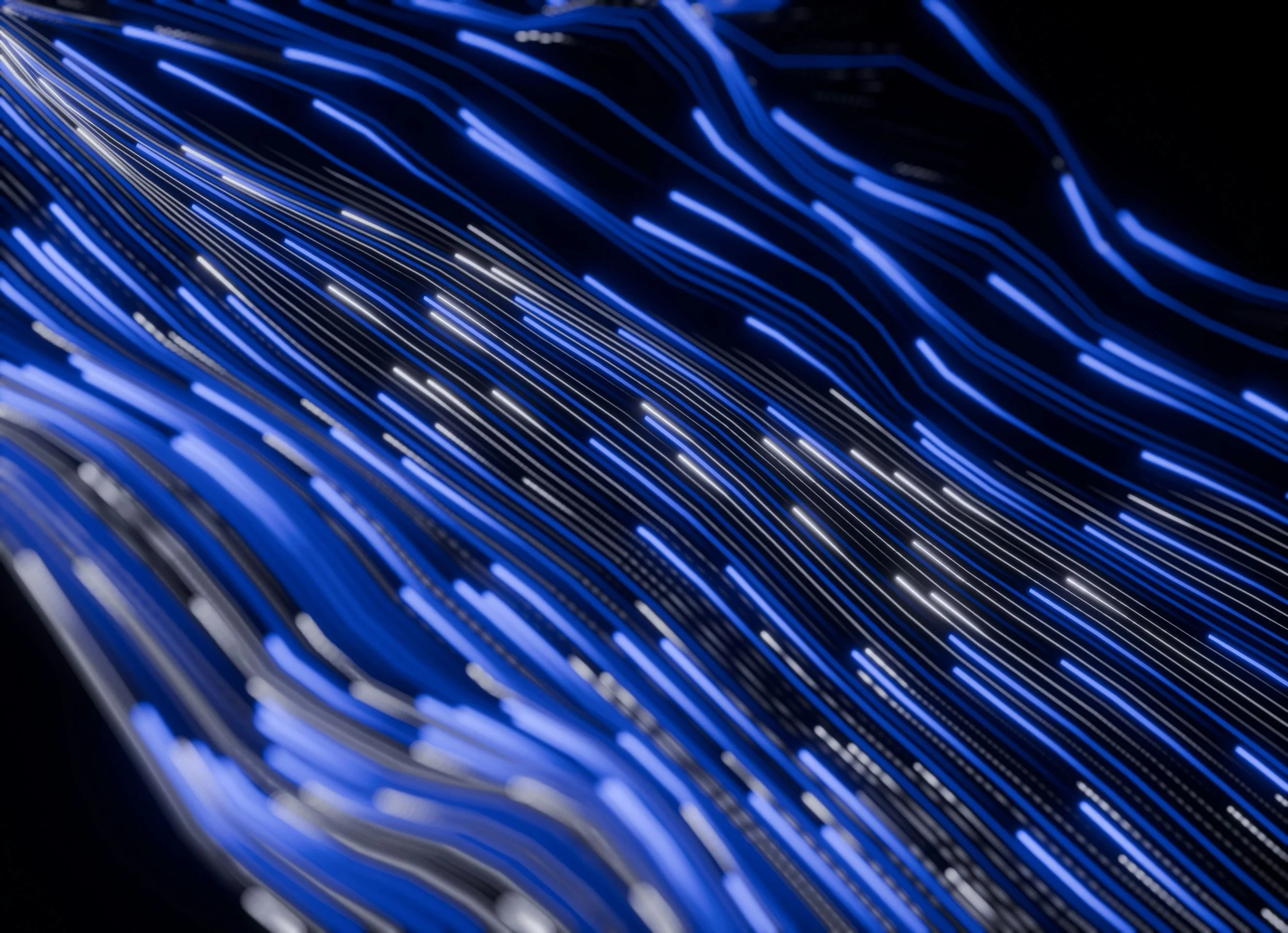 Close-up of illuminated blue and white fiber optic cables against a dark background.