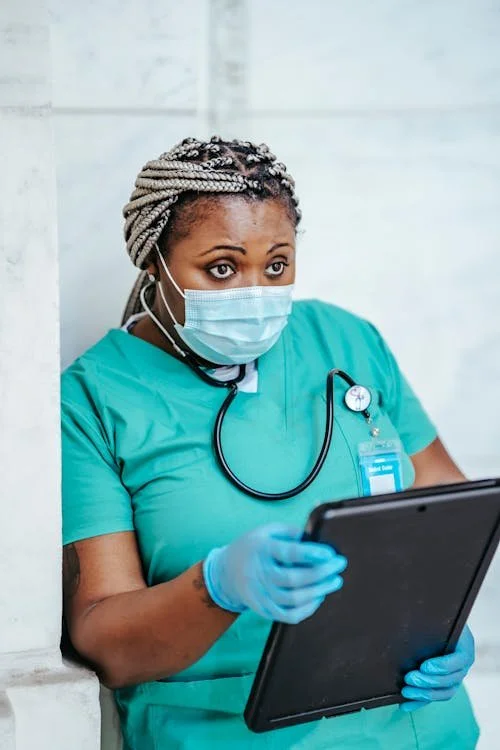 A woman seated in a hospital room reviews paperwork carefully, representing the important step of understanding medication instructions before discharge.