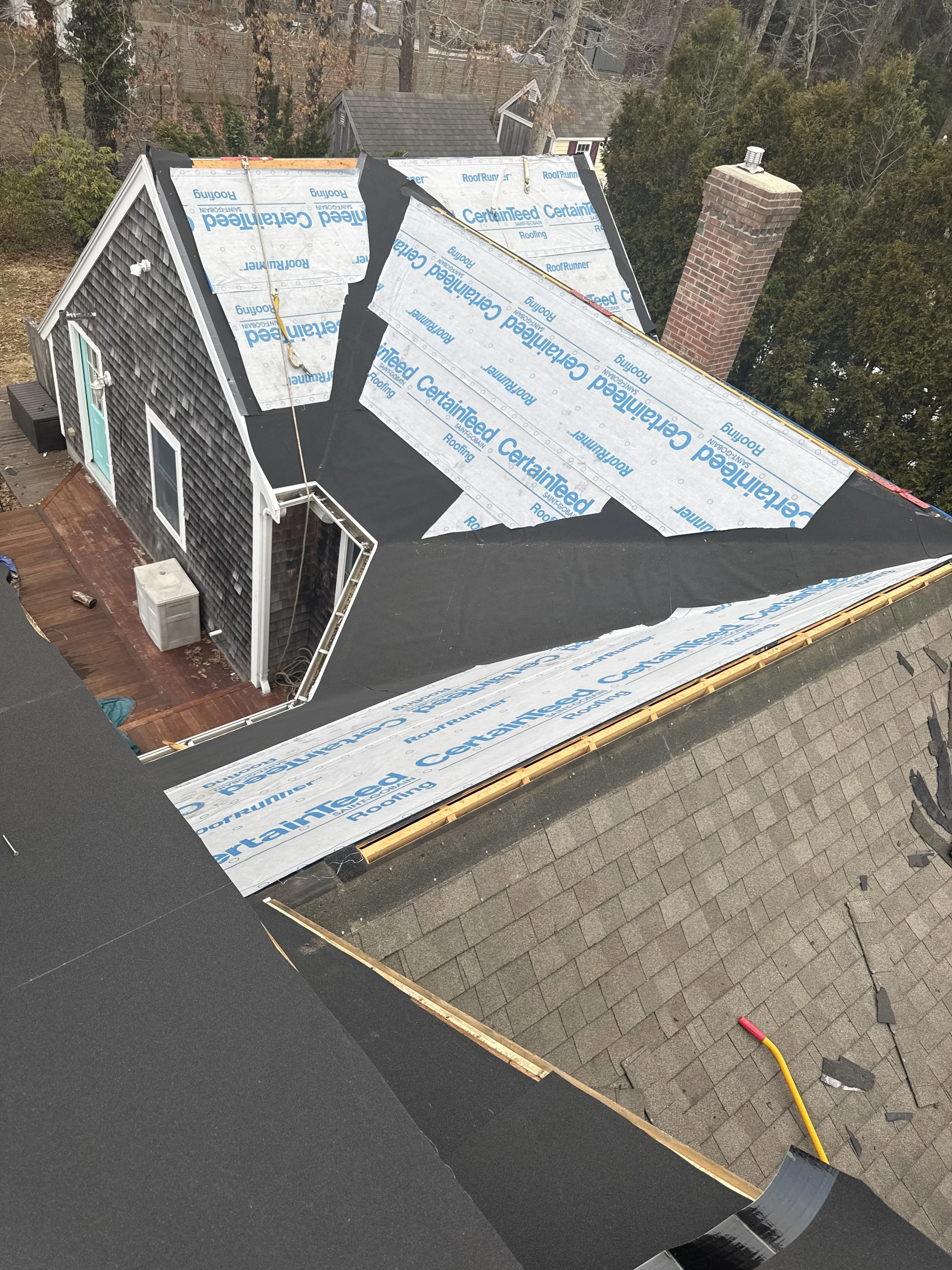 Roof replacement in Cape Cod, MA with new underlayment installation and partial shingle removal on residential home.