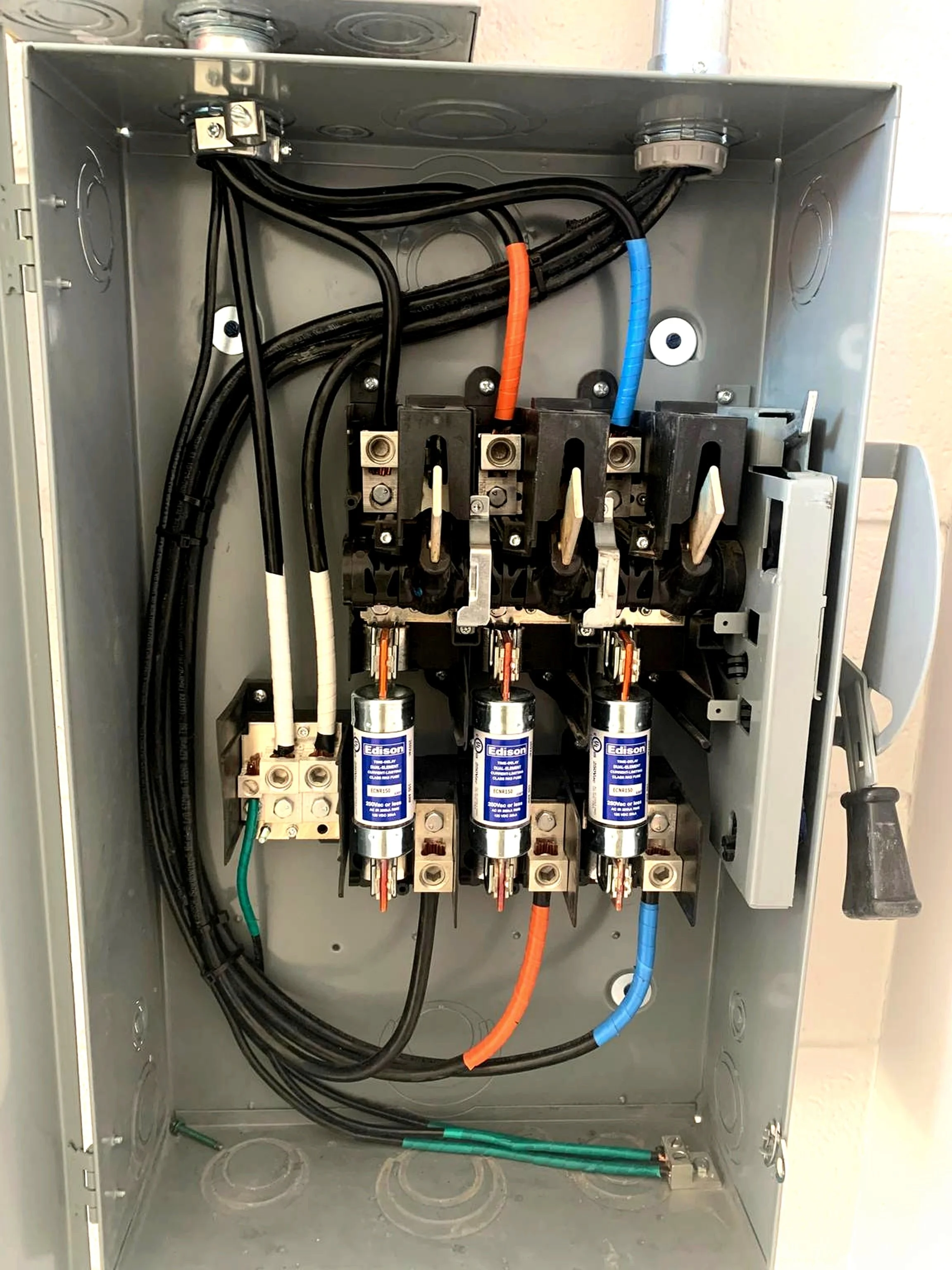 Interior of an electrical panel with wiring, circuit breakers, and contactors inside.