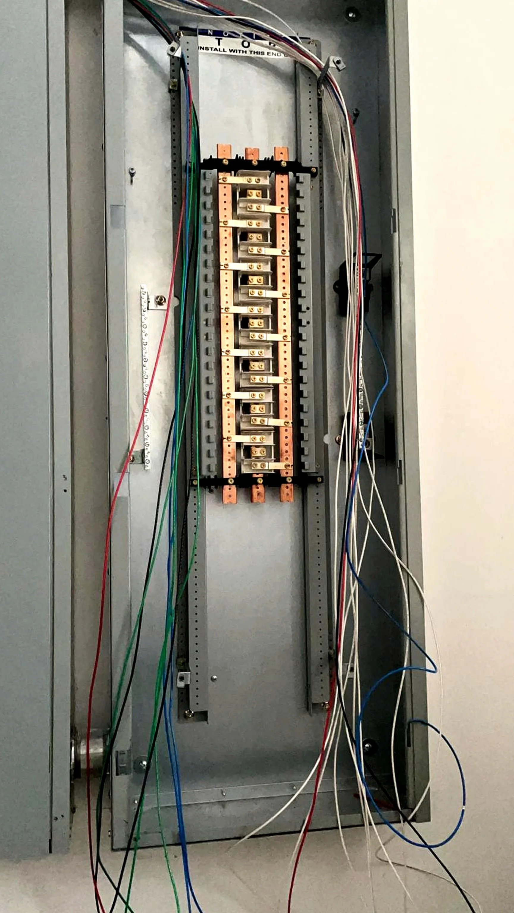 An electrical panel with wiring and connection terminals inside an open metal box.
