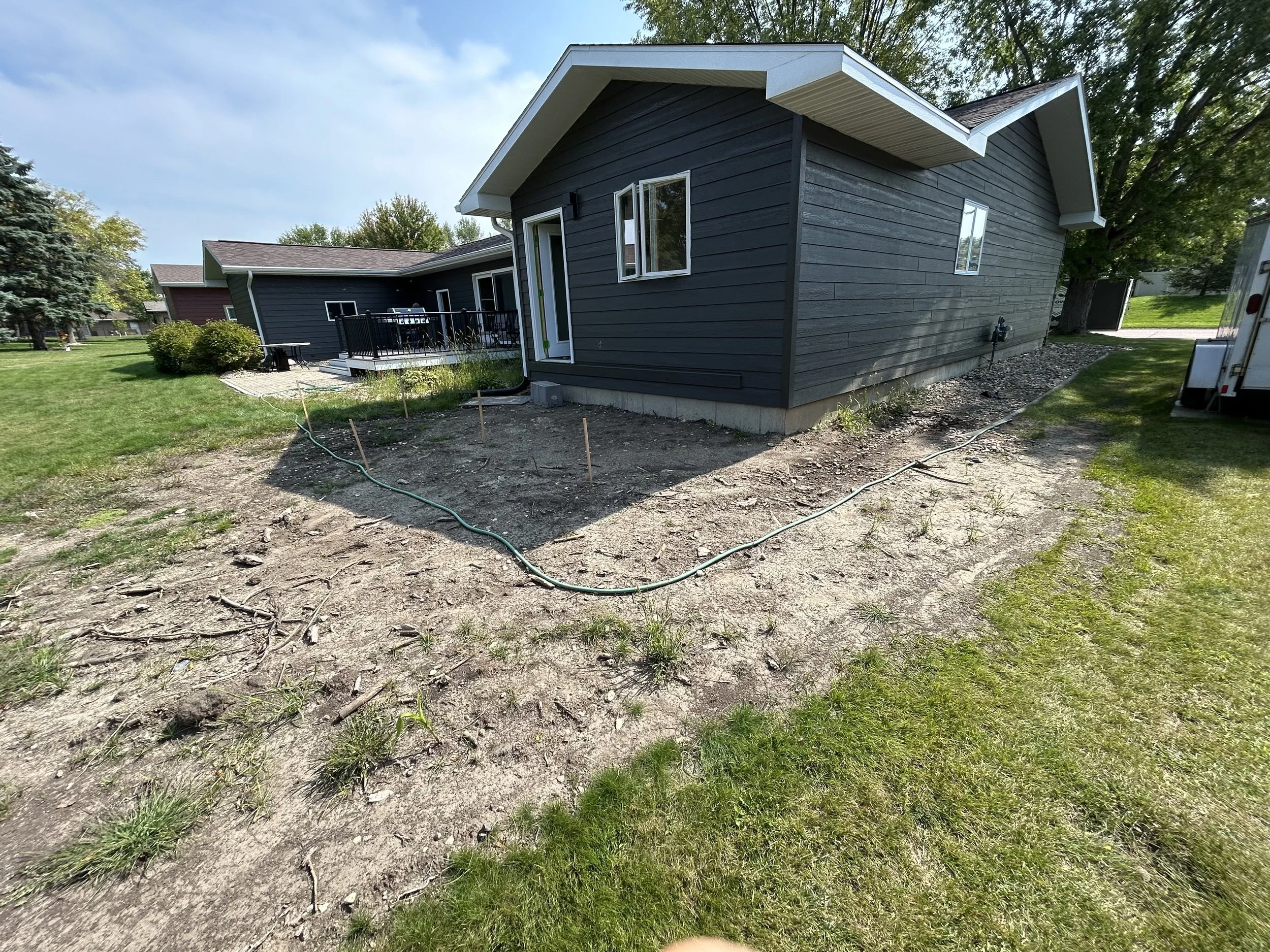 Landscape renovation project in Watertown, SD showing yard preparation and grading before installation. This stage includes clearing, leveling, and prepping the area for new landscaping and outdoor improvements.