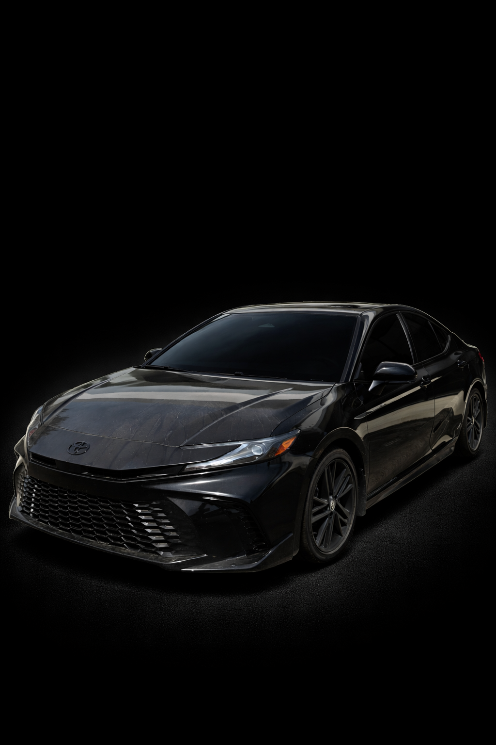 A sleek black Toyota sedan on a dark background.