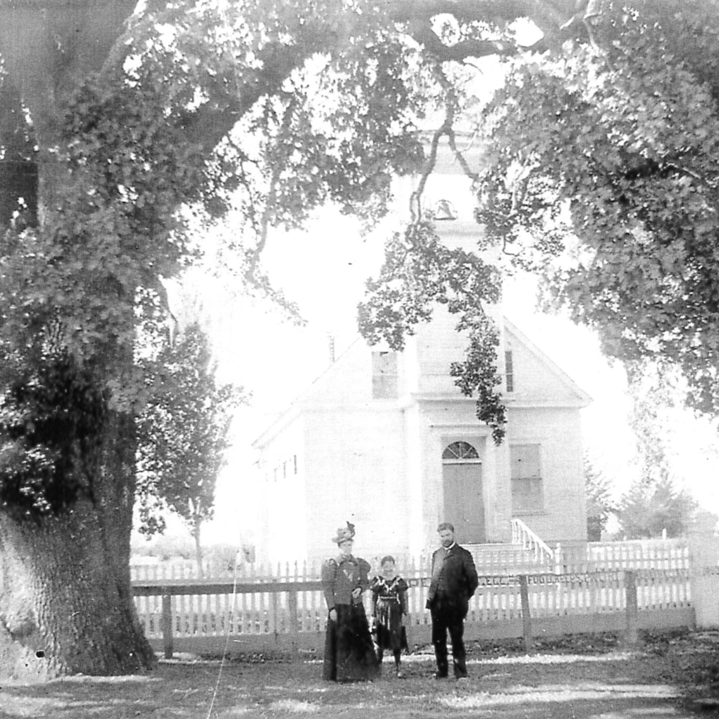a man, woman and child stand in front of mountain view cumberland church in  1860